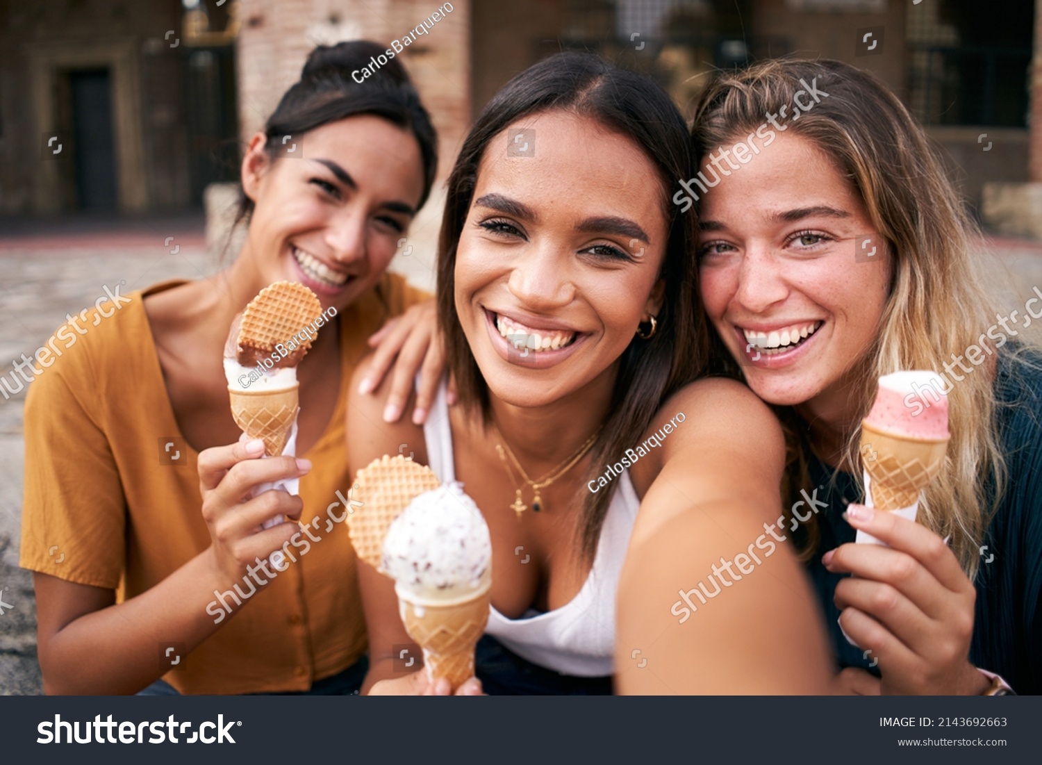 Three young smiling hipster women taking selfie outdoors in summer clothes eating ice cream. Female 20s friends having fun and enjoying summer vibes together. Holiday vacation time #2143692663