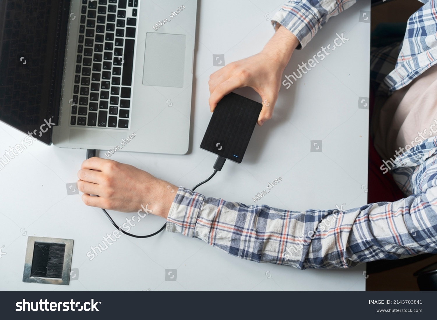 holding backup external hdd with archive and connect it to the laptop #2143703841