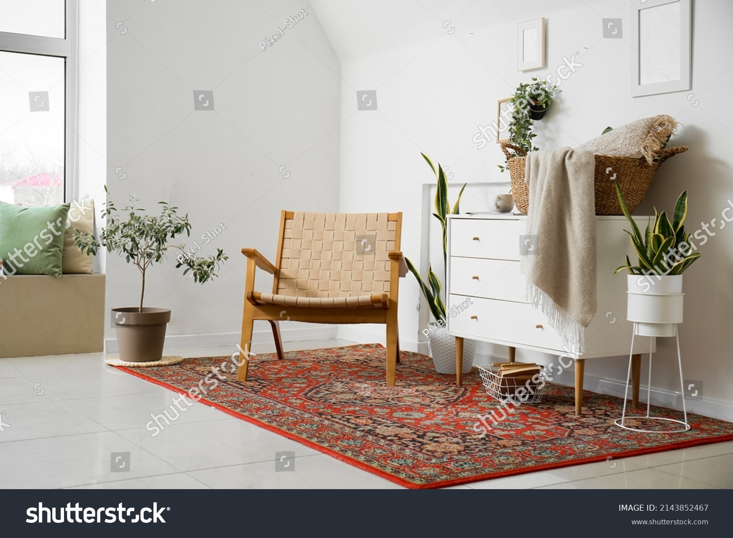 Interior of cozy living room with armchair, chest of drawers and vintage carpet #2143852467