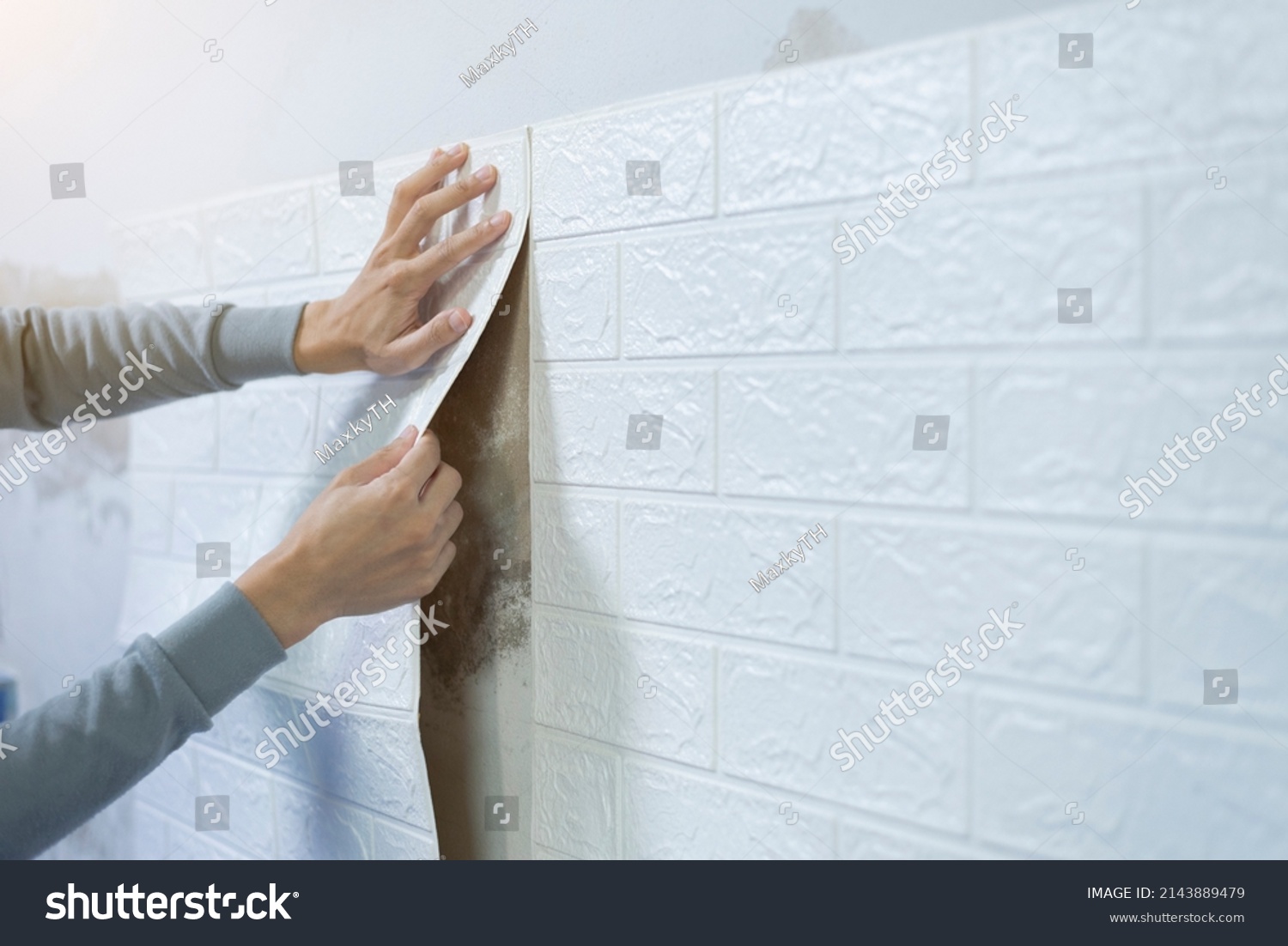 Worker hands sticking wallpaper on wall, Home decoration by yourself, Copy space. #2143889479