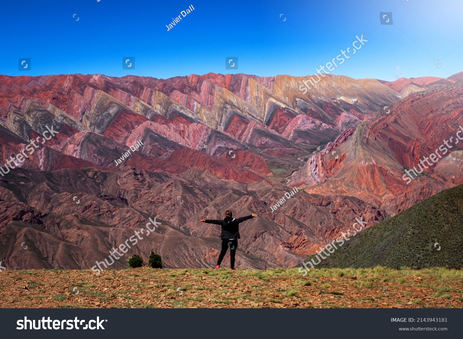 Selective Focus. The Hornocal, Jujuy Argentina. Hill of fourteen colors. Happy person in El Hornocal. person posing from behind in El Hornocal. Beautiful landscape of Argentina #2143943181