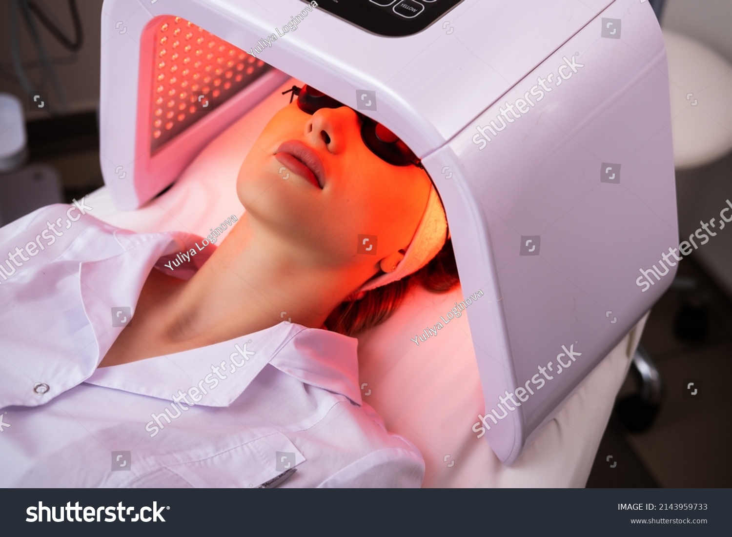 Express facial treatment with led therapy. Beautiful girl on a light therapy procedure. LED lamp with red light. Safe skin care. #2143959733