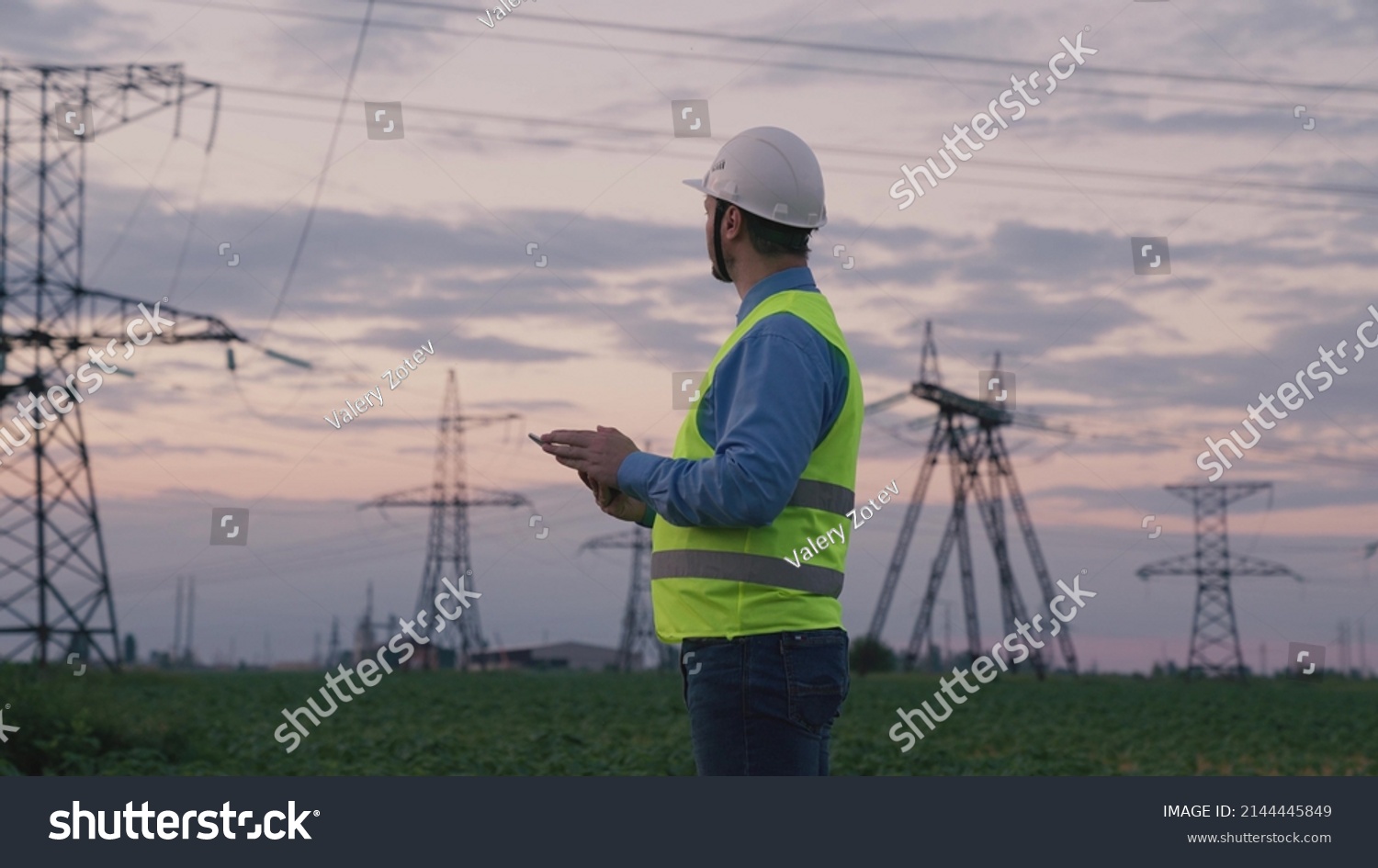 technology concept with high voltage power lines. electrical engineer helmet digital tablet sunset. power engineer power plant high voltage voltage energy. concept electrical engineer working sunset. #2144445849