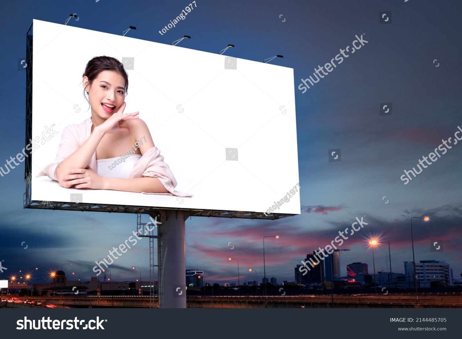 Portrait of beautiful charming young Asian woman posing facial and sitting with white table advertise on billboard blank for outdoor advertising poster or blank billboard for advertisement. #2144485705