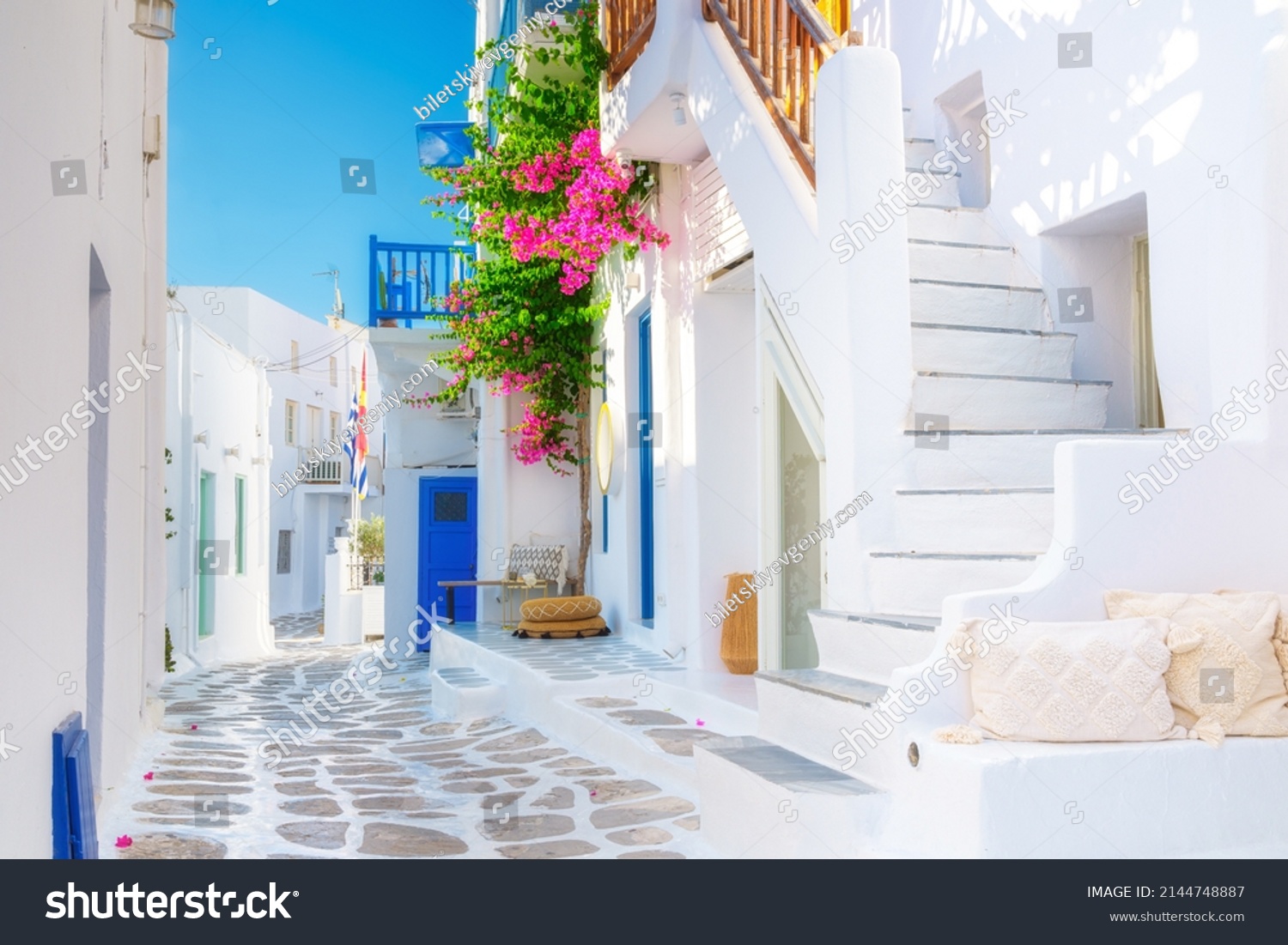 The island of Mykonos, Greece. Streets and traditional architecture. White-colored buildings and bright flowers. Travel photography. #2144748887