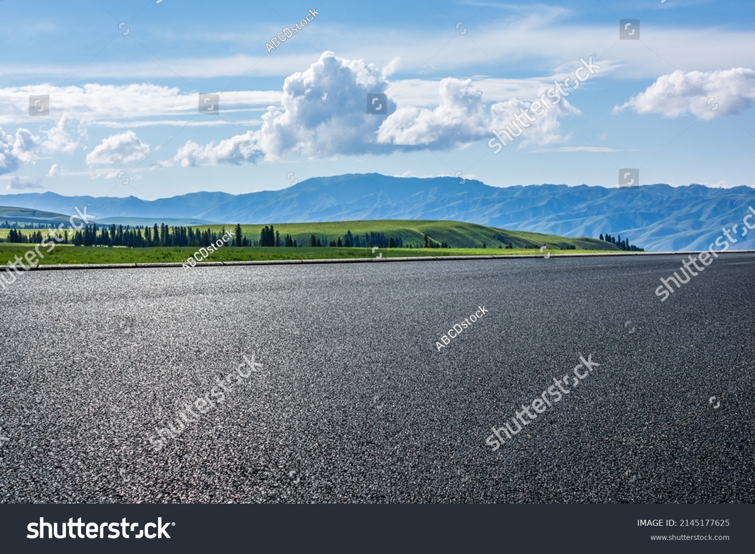 Empty asphalt road and green grassland and mountain under blue sky  #2145177625