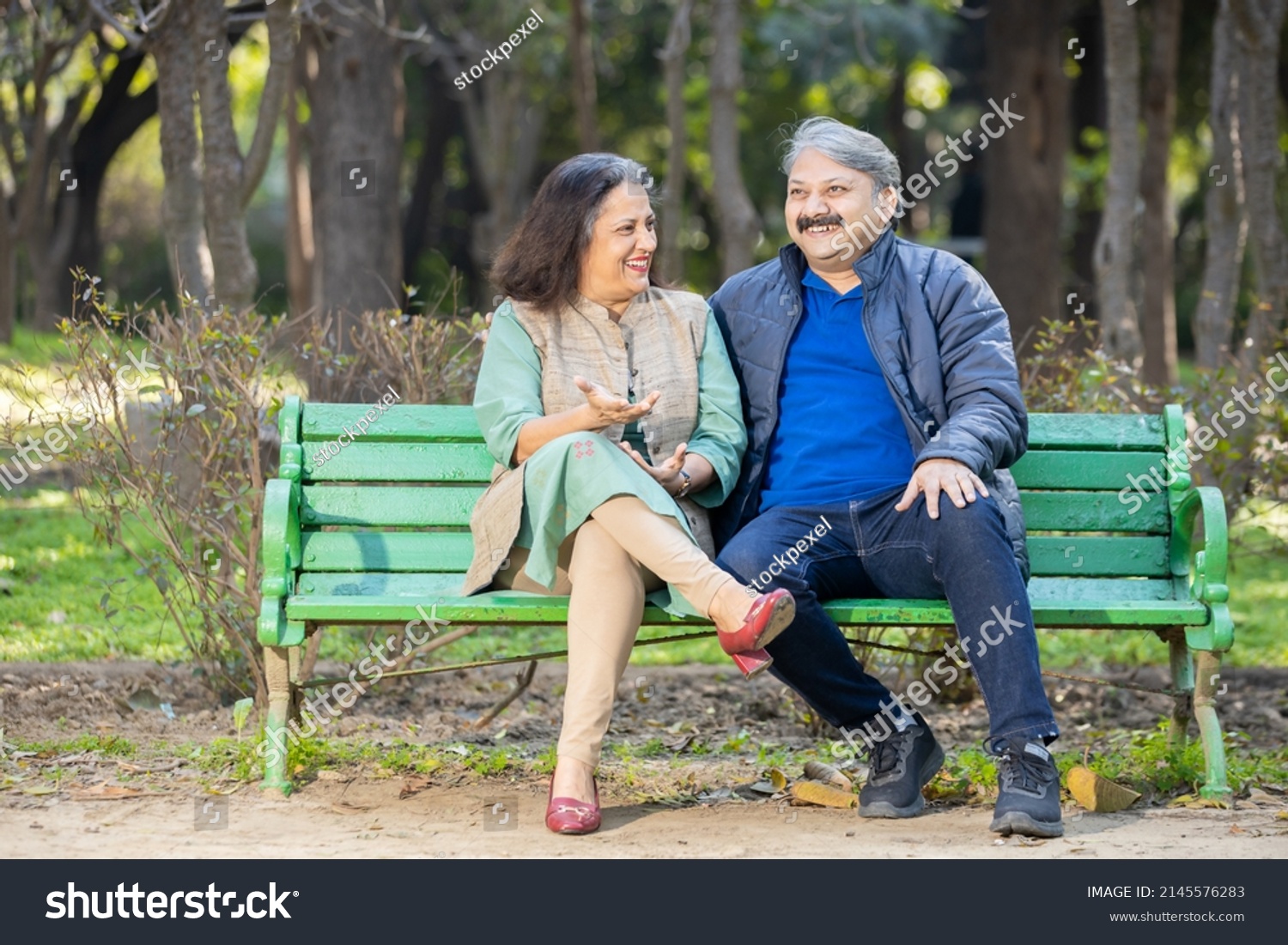 Happy Indian or asian senior couple talking laughing while sitting on the bench, Old man and woman relaxing at park spend time together, relationship and people concept. #2145576283