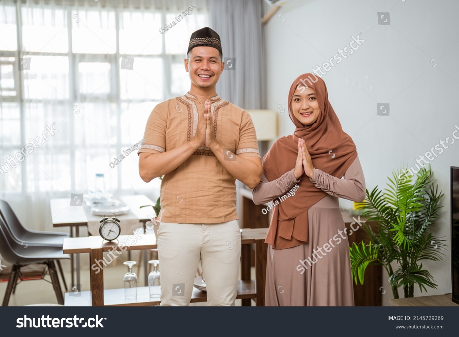 muslim couple with greeting gesture looking at the camera and smile #2145729269