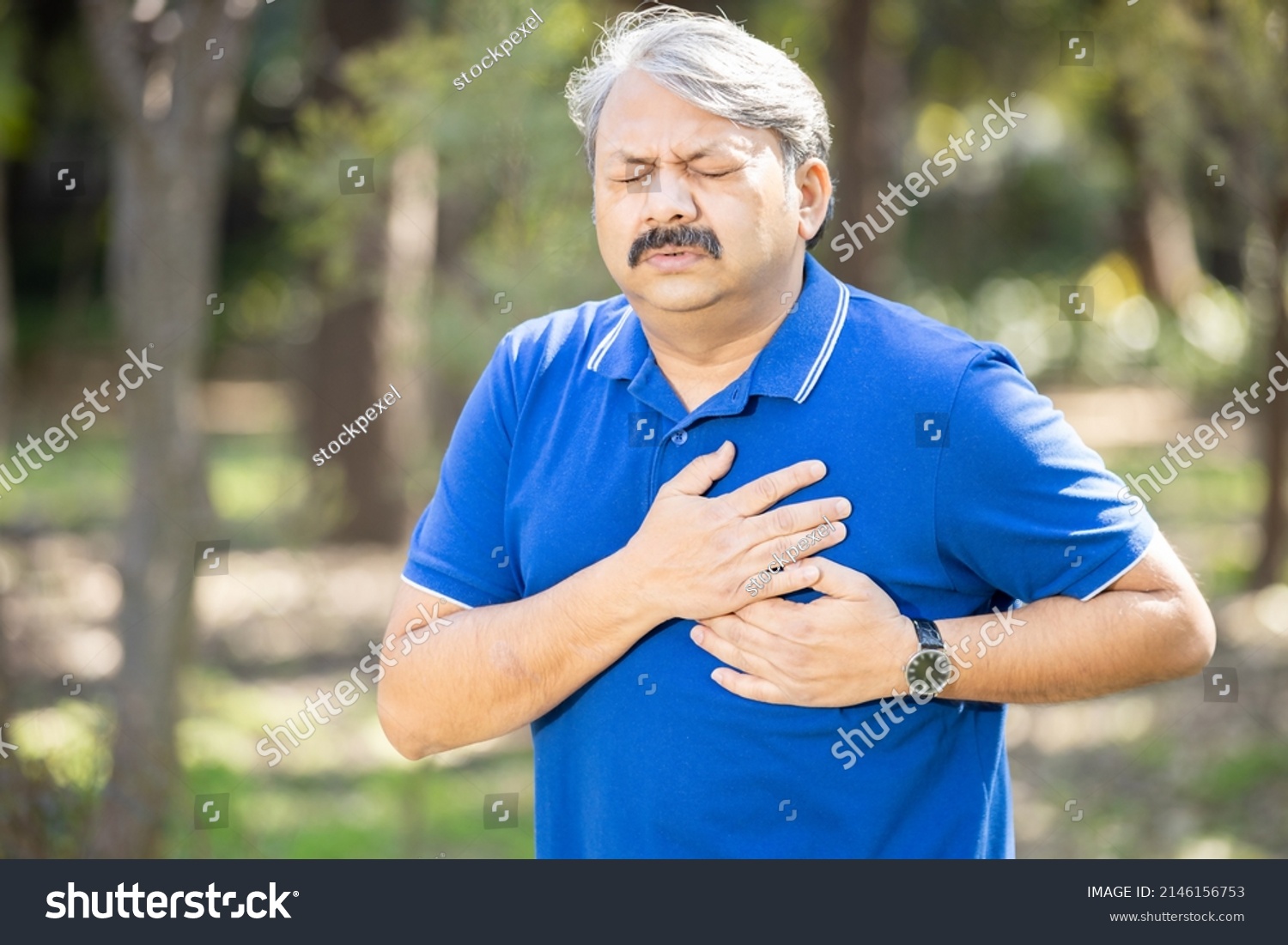 Senior Indian asian male presses hand to his chest as he is suffering from bad pain or heart attack at park outdoor, old people heart disease problem, healthcare concept. #2146156753