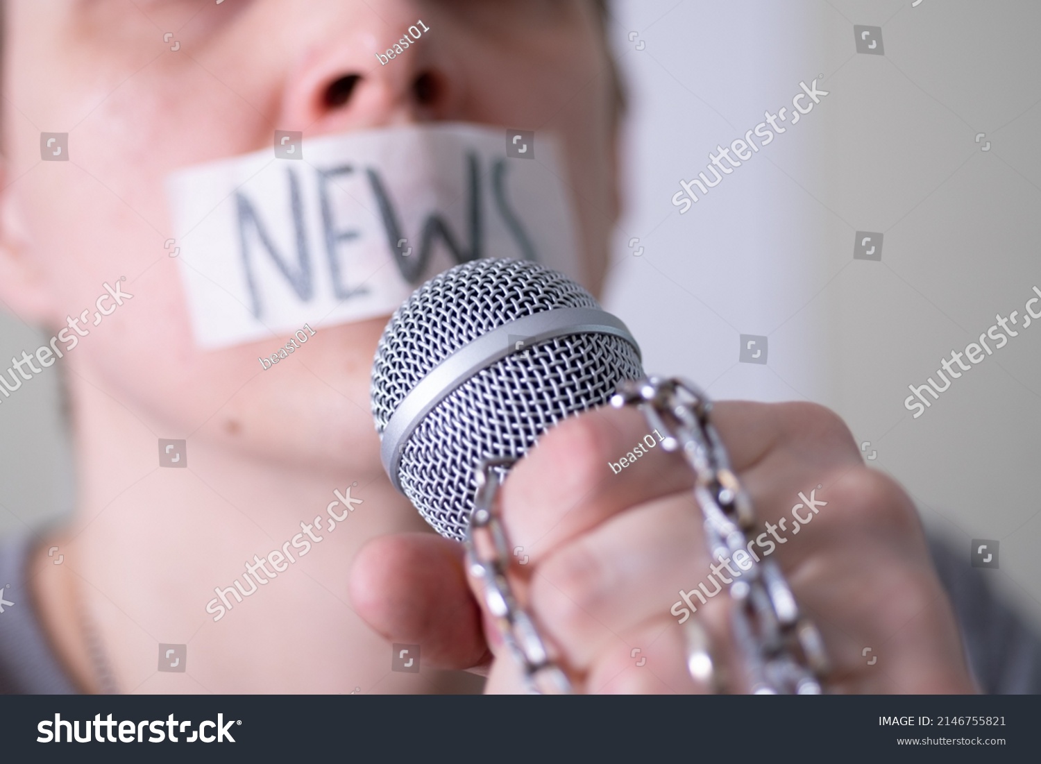 A man gags his mouth with duct tape saying news trying to speak into a microphone. The concept of World Press Freedom Day. #2146755821