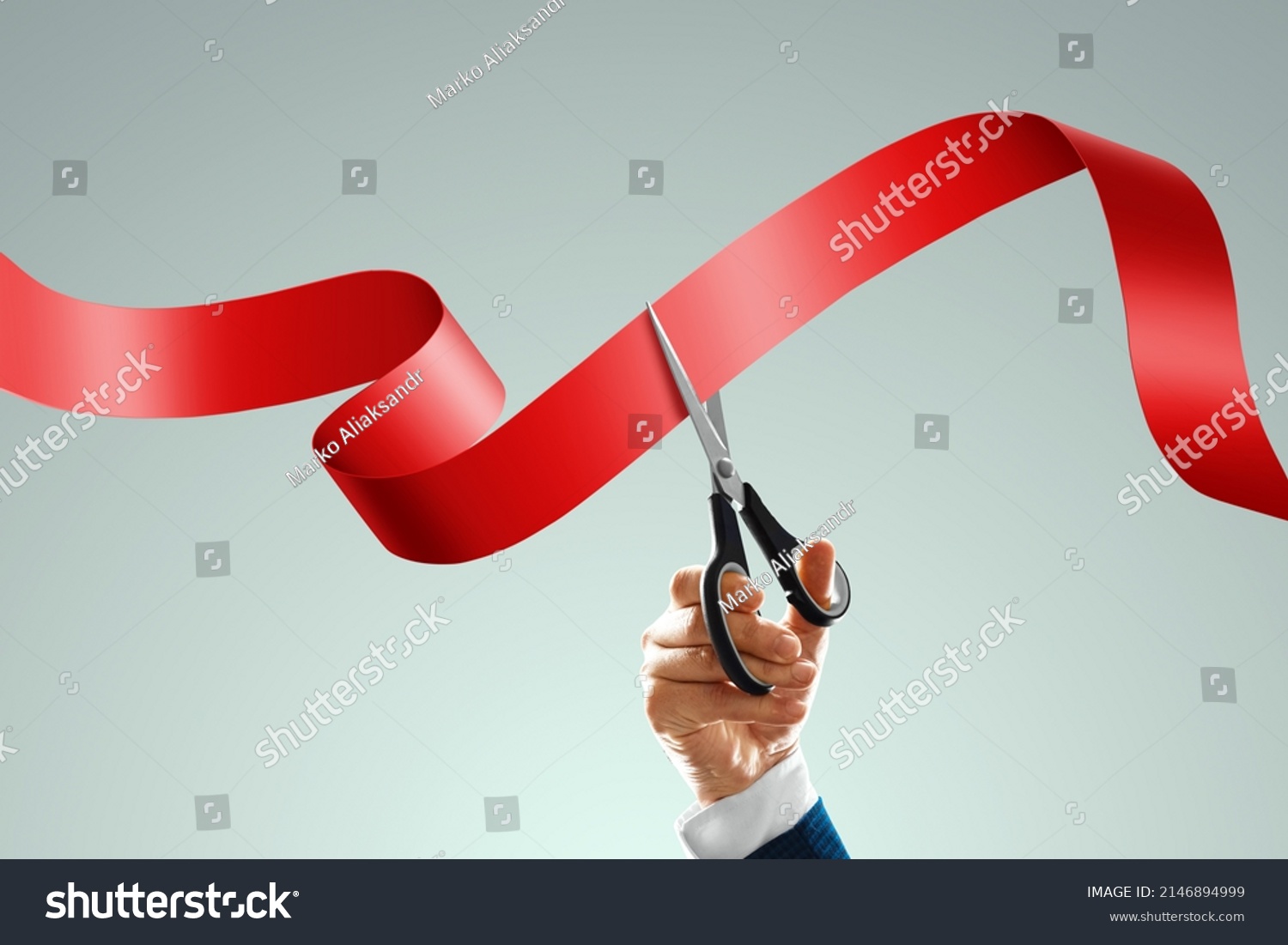 Grand opening with red ribbon and scissors. A businessman's hand holds scissors cuts a red ribbon on a light background. Close-up, copy space #2146894999