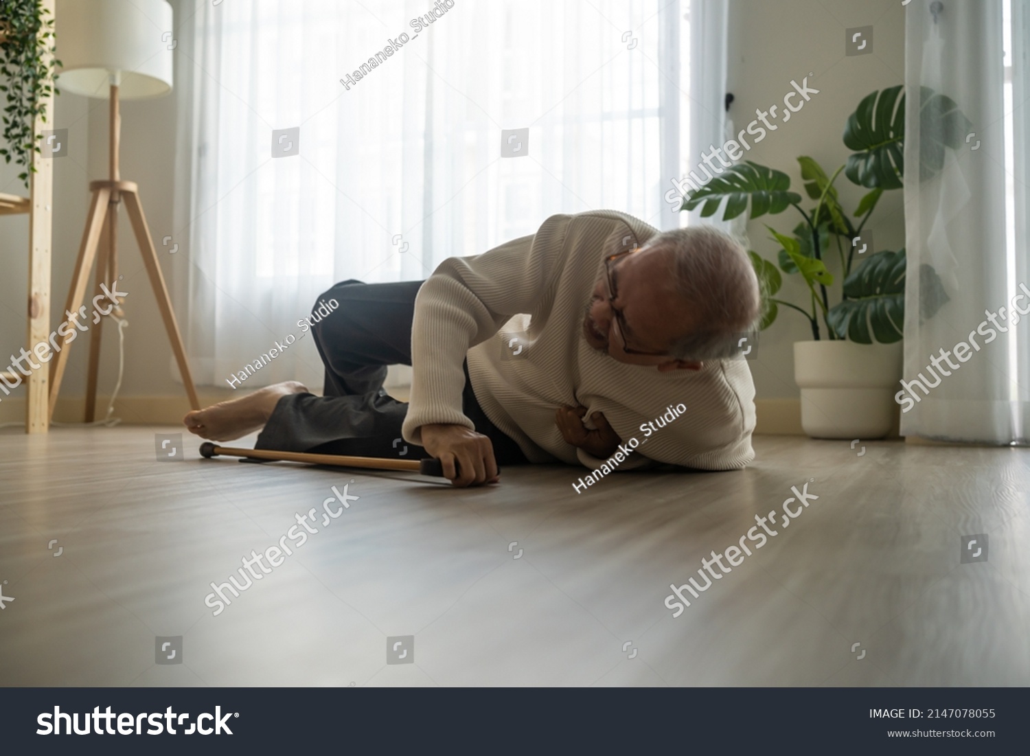 Asian senior male falling on the ground while walk with walker at home. Elderly older mature grandfather having an accident after doing physical therapy alone after retirement in living room in house. #2147078055