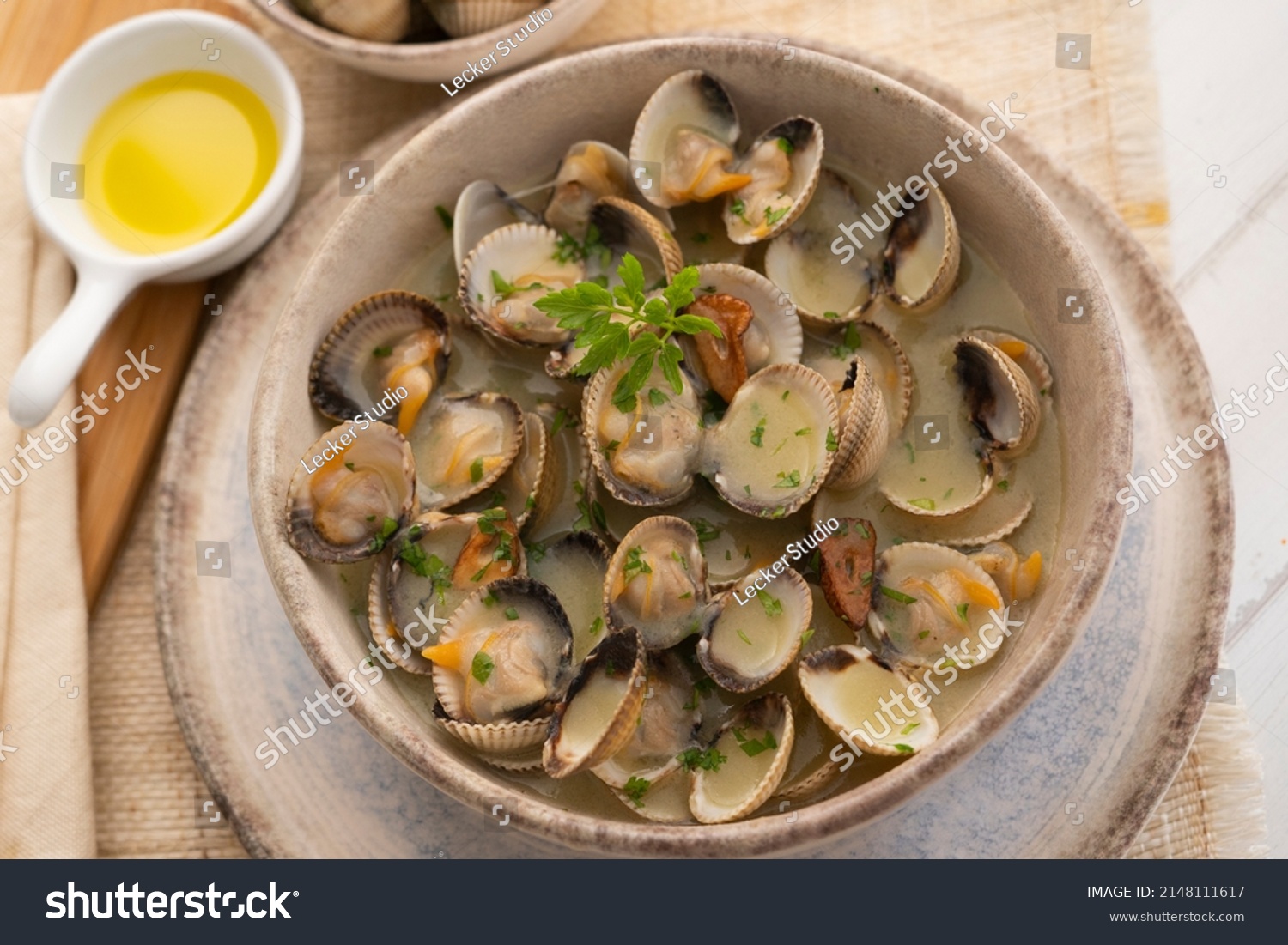 Cockles cooked in green sauce. Traditional Basque country recipe. Spanish cover. #2148111617
