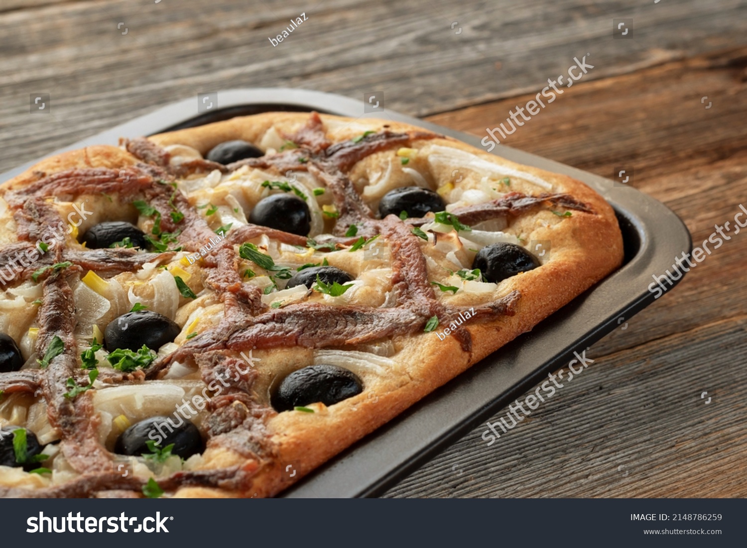Pissaladière is the famous French onion pie. This onion "pizza" with anchovies and olives comes from Nice and can be made with bread or cooked dough. #2148786259
