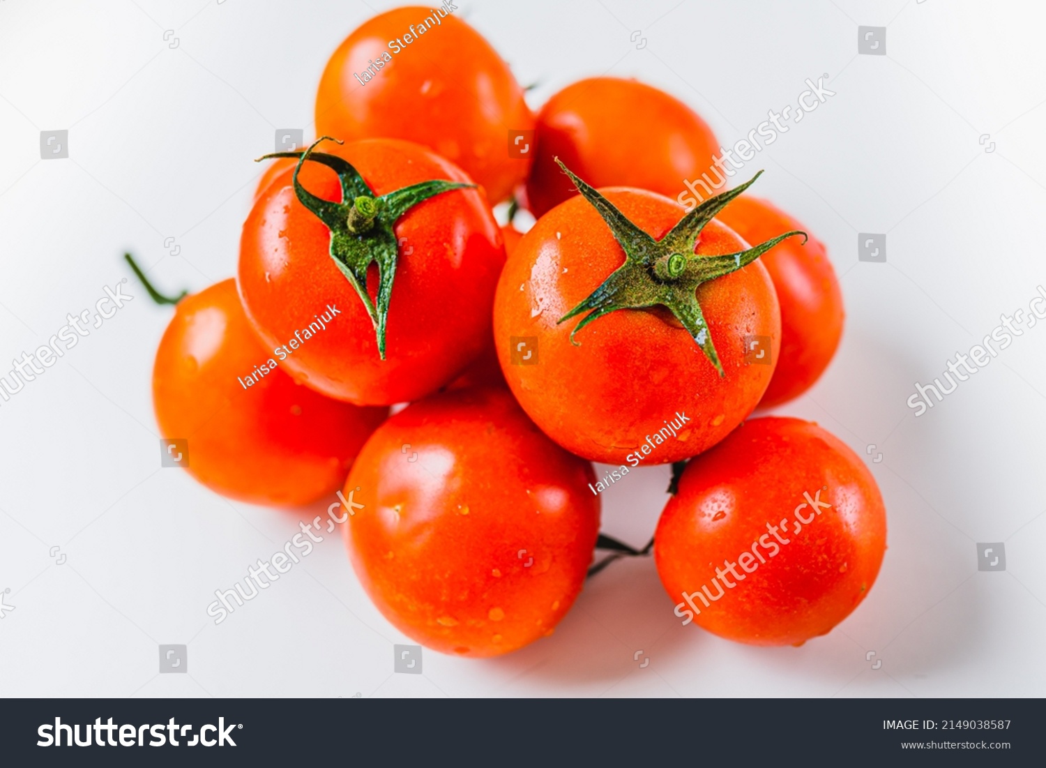 Bunch of ripe tomatoes with one source of natural light. Ripe tomatoes on vine. Ripe red tomatoes in water drops #2149038587