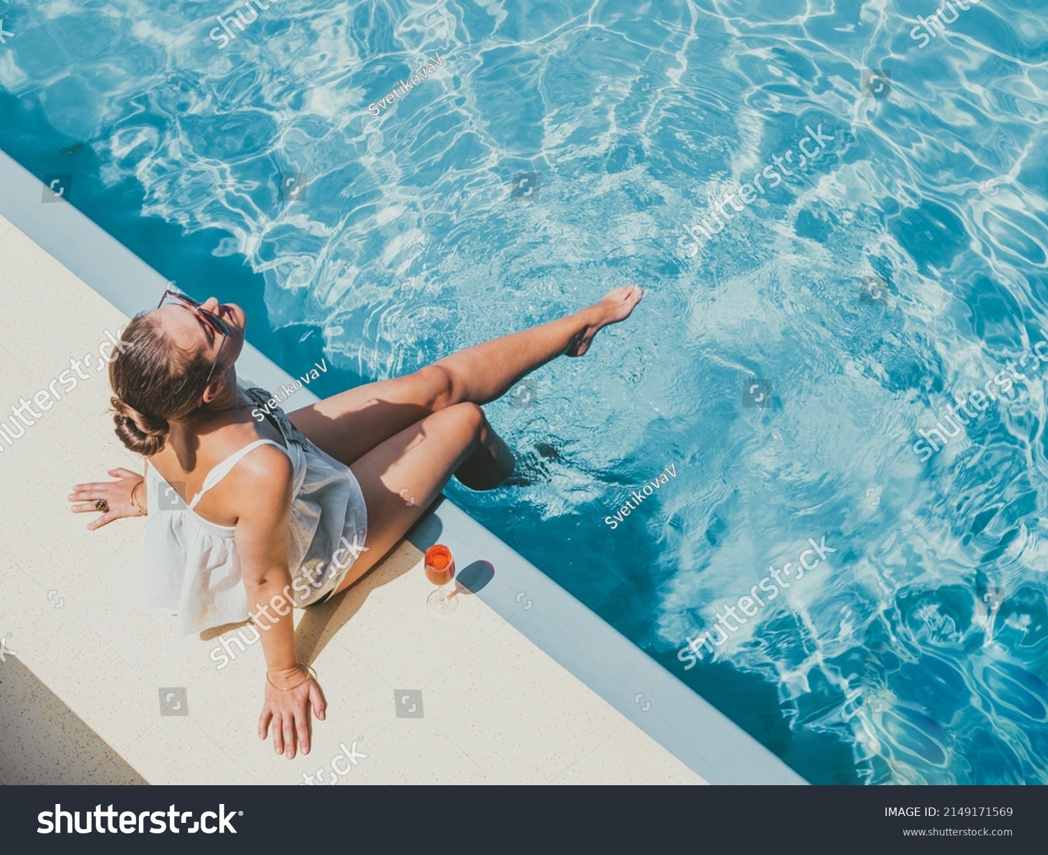 Fashionable woman sitting by the pool on the empty deck of a cruise liner. Closeup, outdoor, view from above. Vacation and travel concept #2149171569