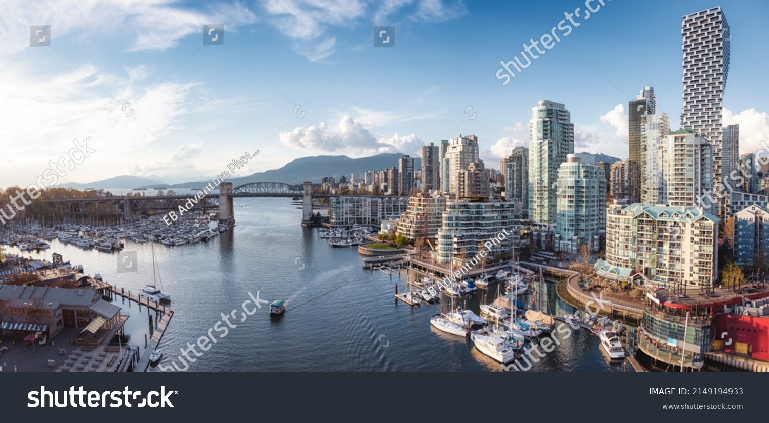 Panoramic Aerial View of Granville Island in False Creek with modern city skyline and mountains in background. Downtown Vancouver, British Columbia, Canada. #2149194933