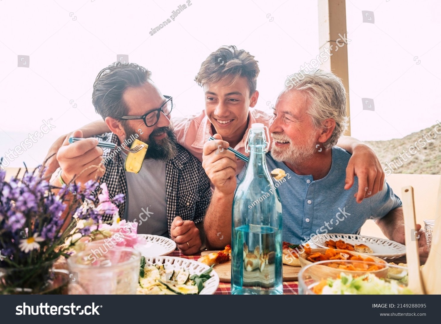 Father grandfather and son eaing together having fun. father's day concept celebration with men family enjoying meal on the table. Cheerful man young adult and mature laughing and having lunch #2149288095