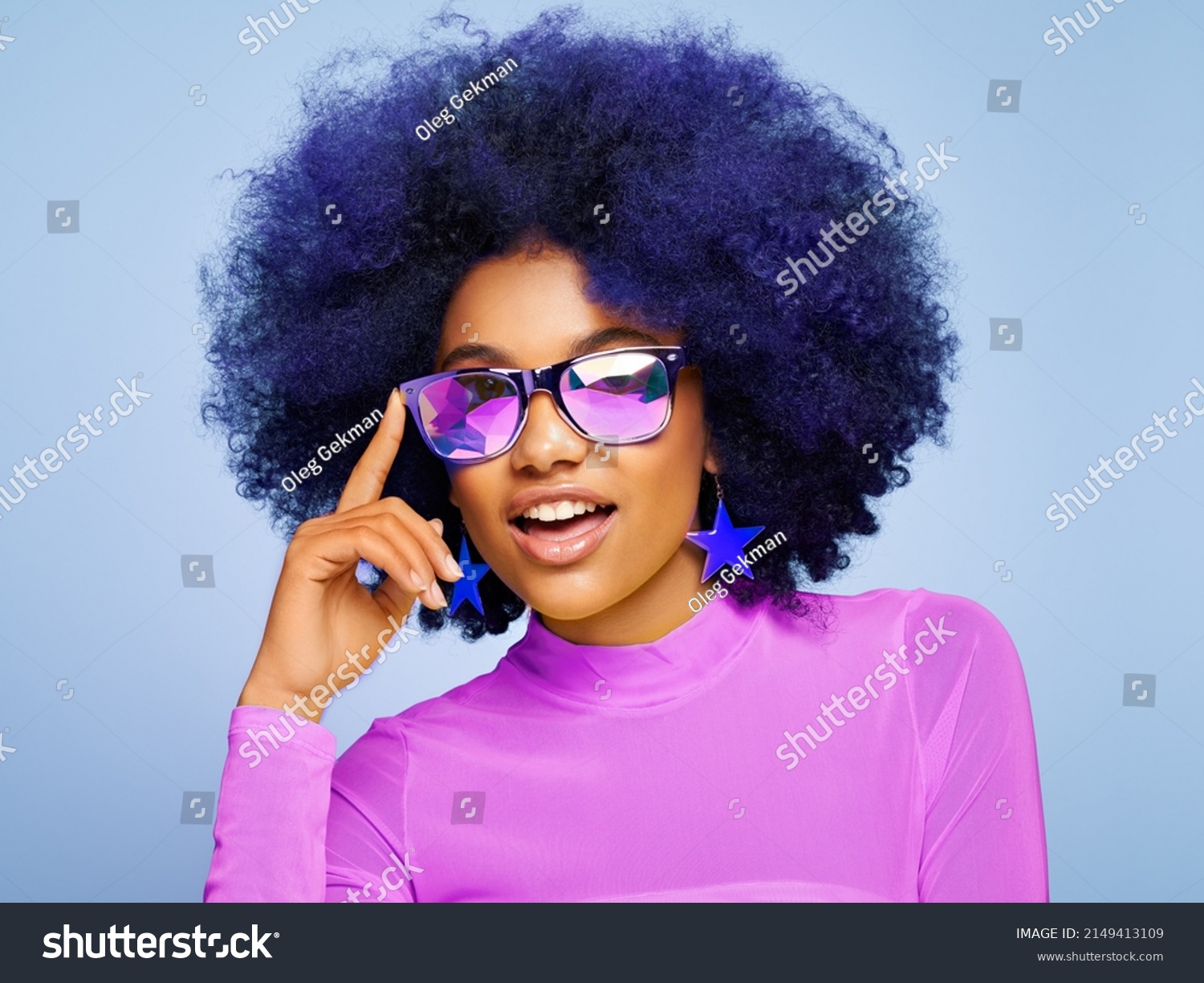 Beauty portrait of African American girl in colored holographic sunglasses. Beautiful black woman on blue background. Cosmetics, makeup and fashion #2149413109