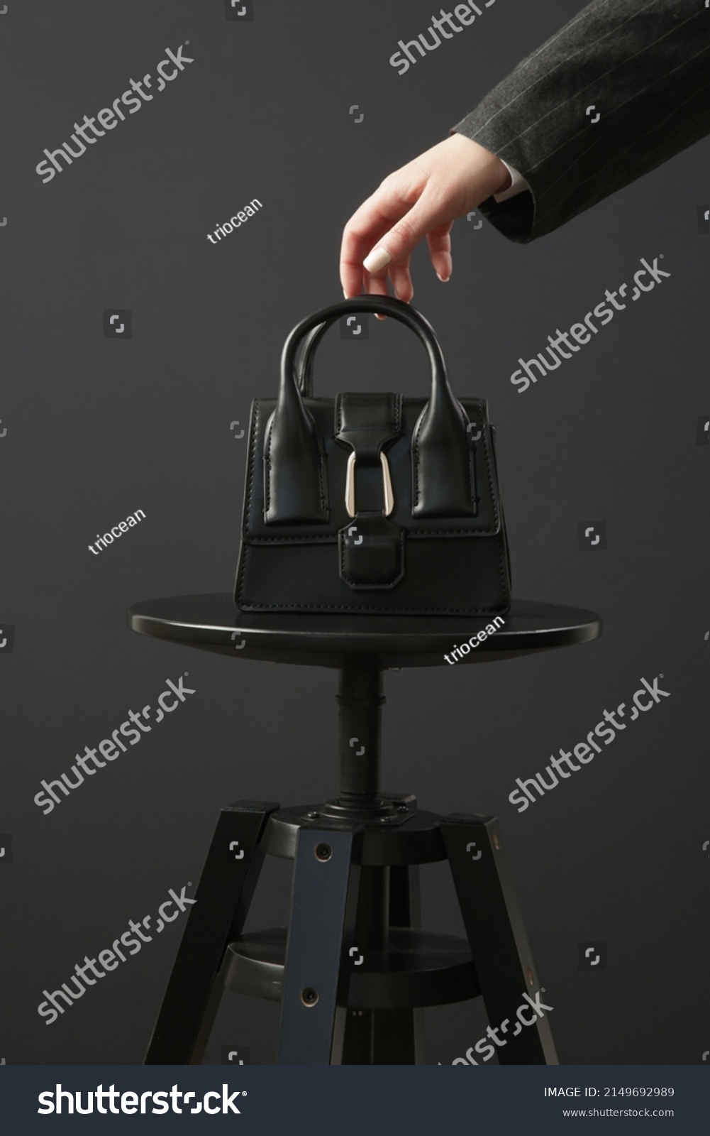 Top handle mini black bag made in textured, resistant leather. Studio shot on black background. #2149692989