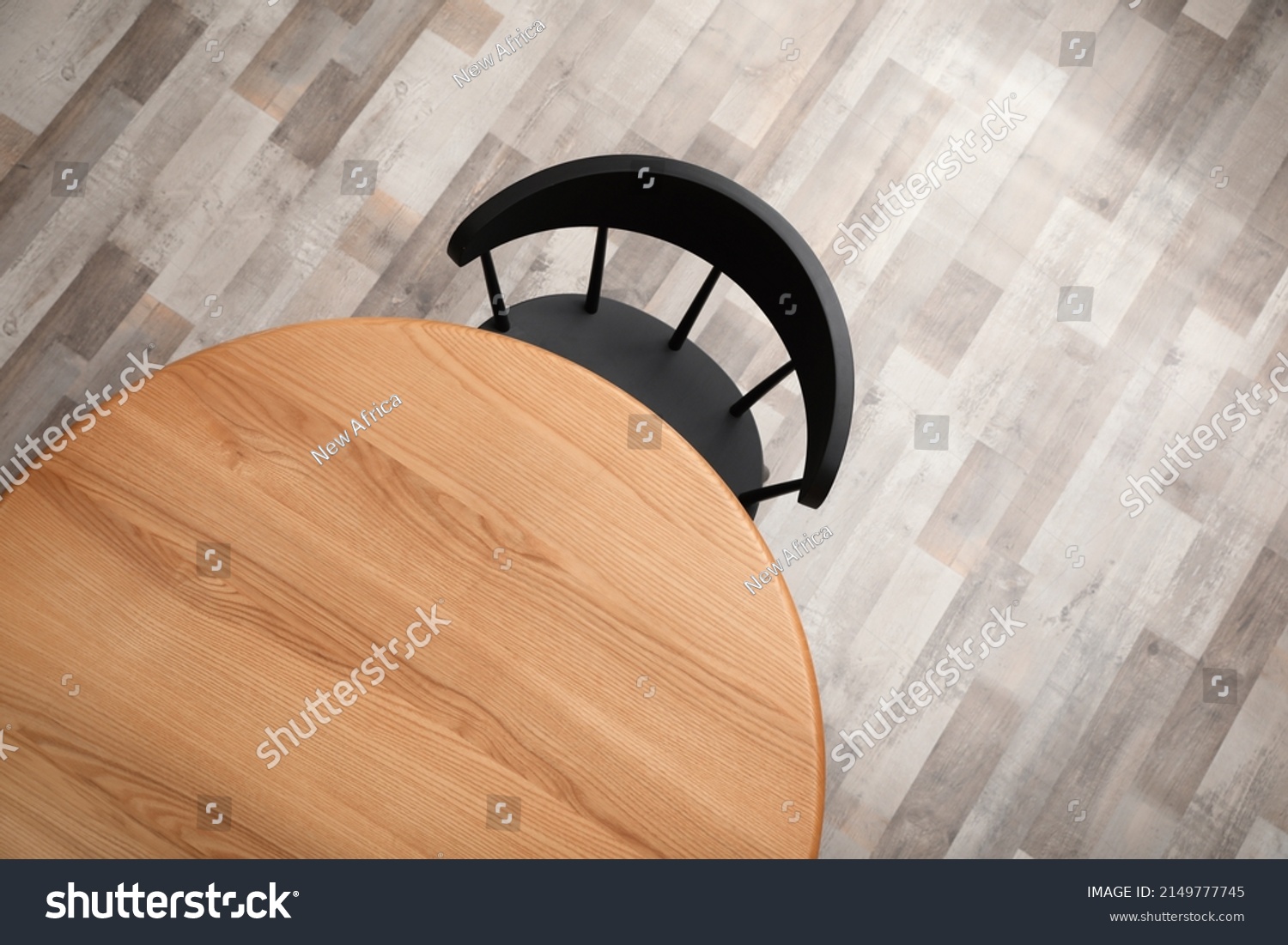 Round wooden table and black chair indoors, top view #2149777745