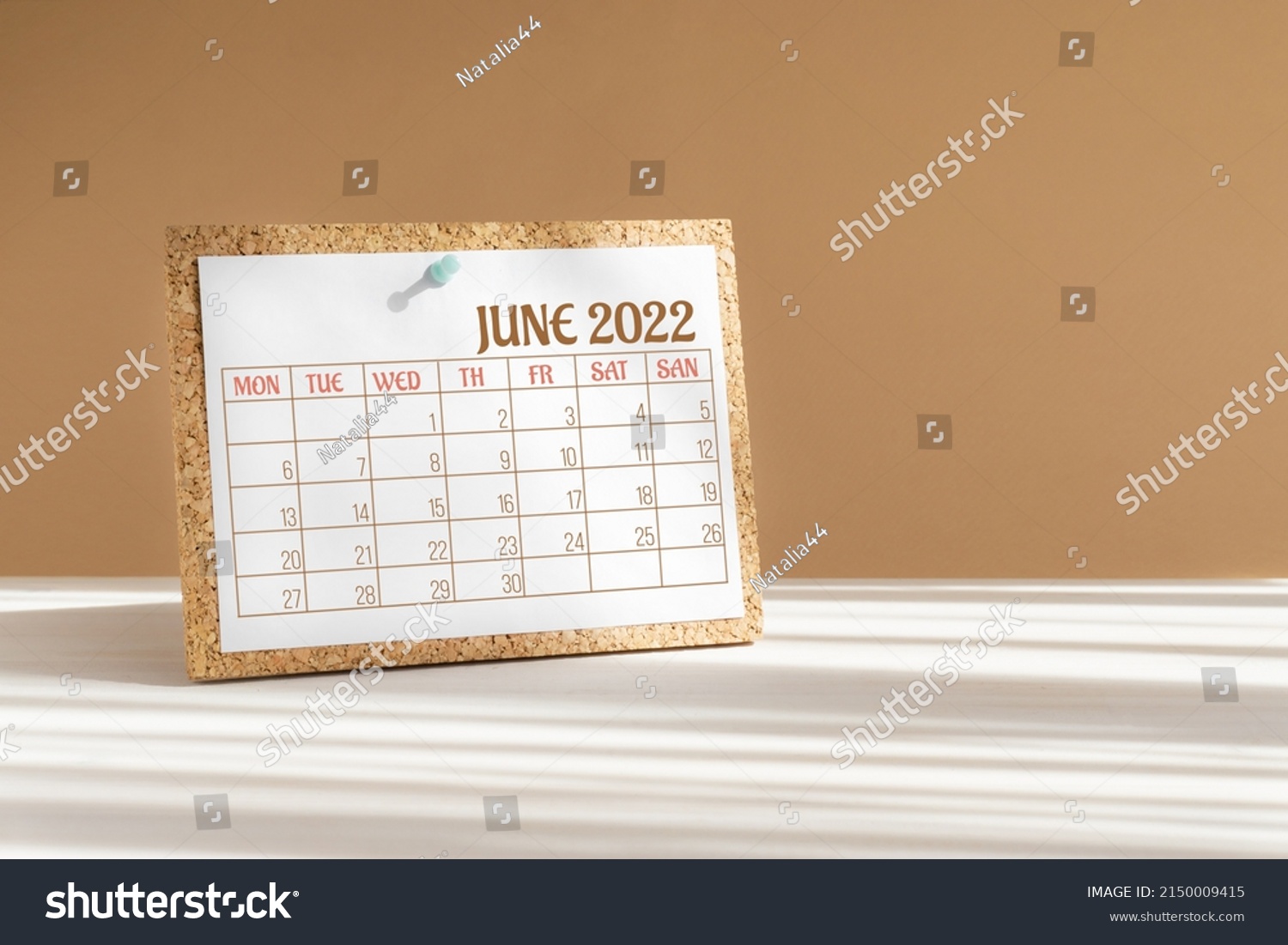 Calendar sheet for 2022. Desktop calendar for month of June, attached to cork board with a button on desktop. Concept of event planning, reminders. #2150009415