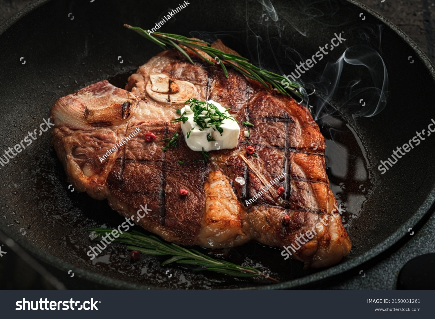 T-bone steak steaming in a grill pan with spices, rosemary and butter. Premium Porterhouse steak on the bone #2150031261