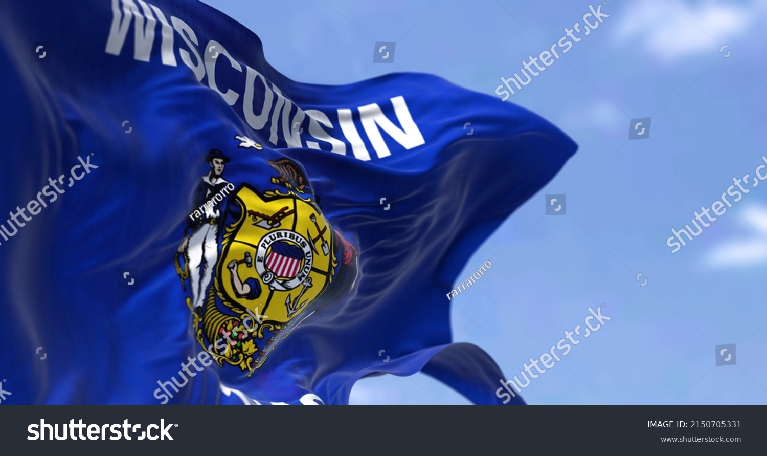 The US state flag of Wisconsin waving in the wind. Wisconsin is a state in the upper Midwestern United States. Democracy and independence. #2150705331