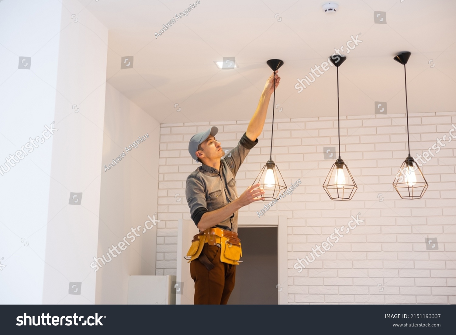 Electrician worker installation electric lamps light inside apartment. Construction decoration concept. #2151193337