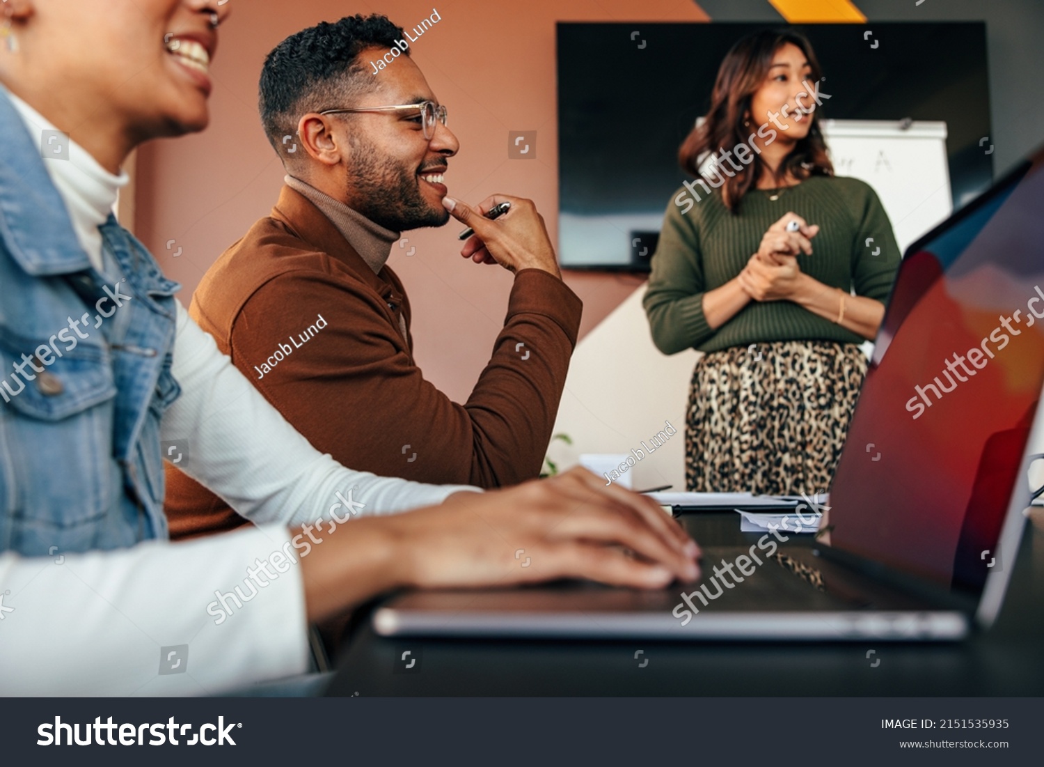 Group of diverse businesspeople having a meeting in a boardroom. Young businesspeople smiling happily during a discussion. Multiethnic businesspeople working together as a team. #2151535935