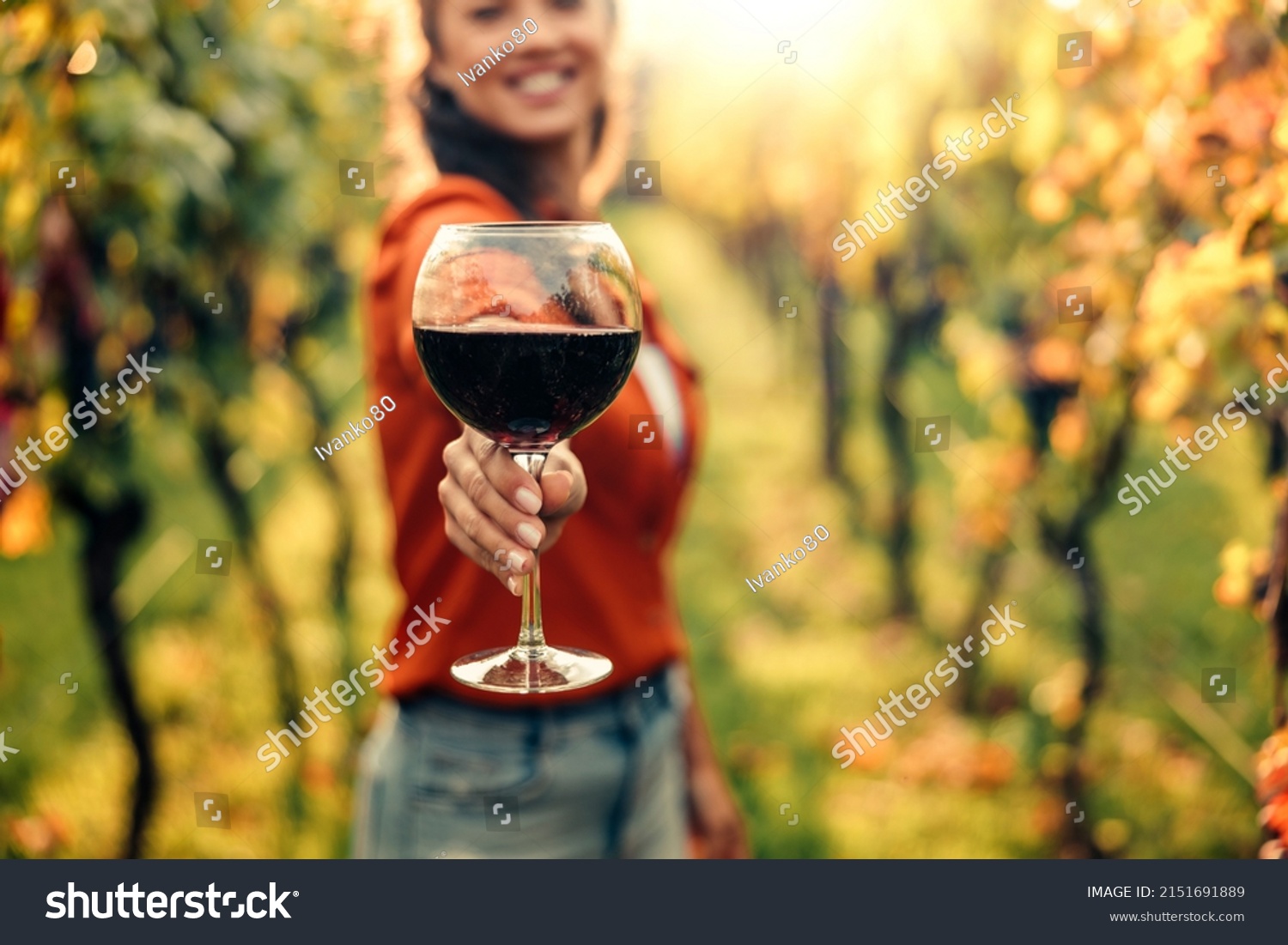Woman tasting wine in vineyard. She is showing glass of wine to camera. #2151691889