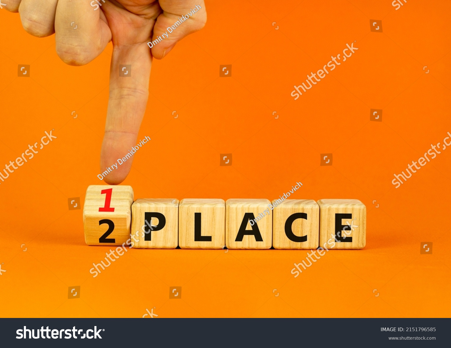 From 2 to 1 place symbol. Businessman turns wooden cubes and changes concept words 2 place to 1 place. Beautiful orange table orange background. Business and from 2 to 1 place concept. Copy space. #2151796585