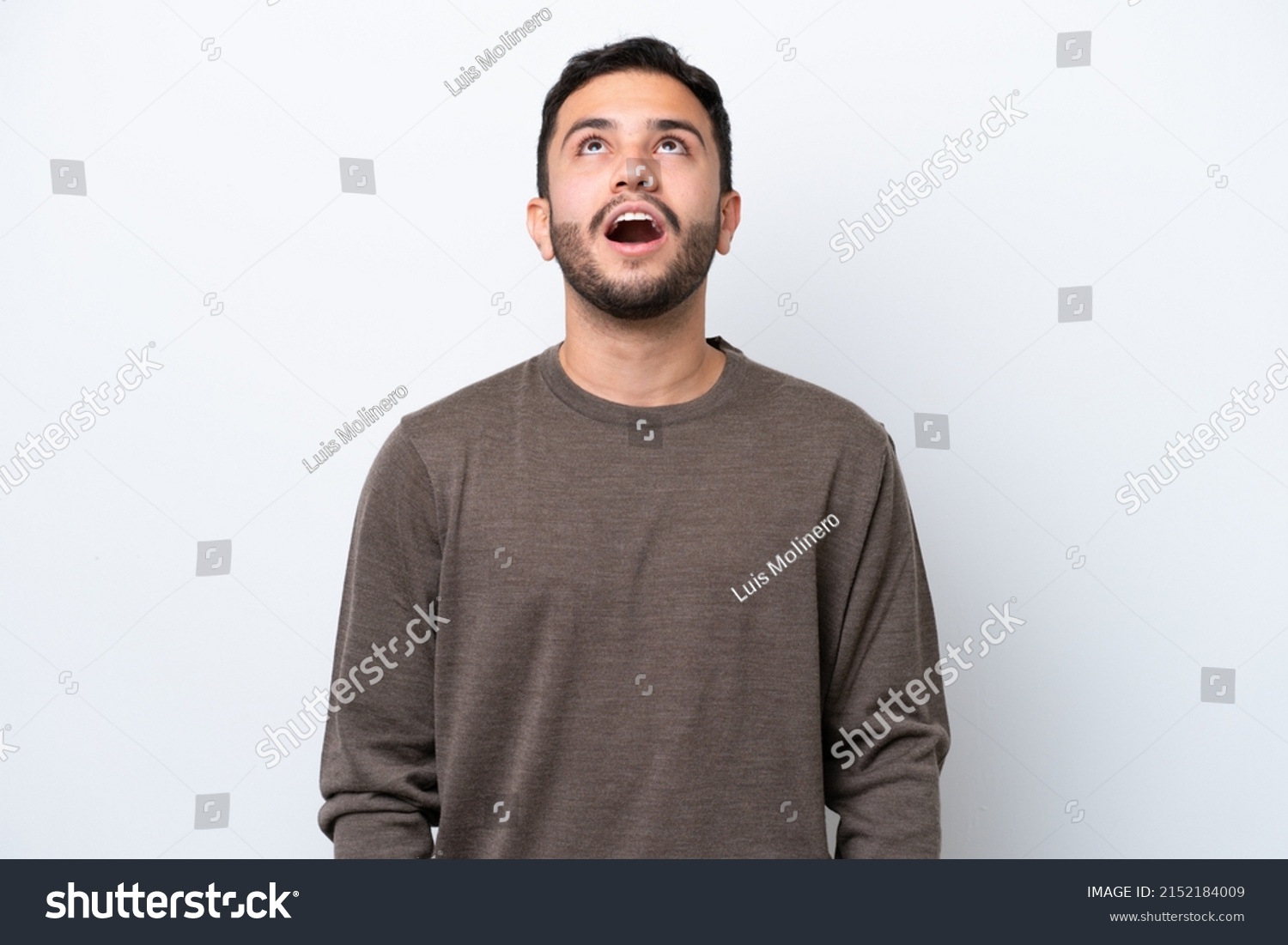 Young Brazilian man isolated on white background looking up and with surprised expression #2152184009