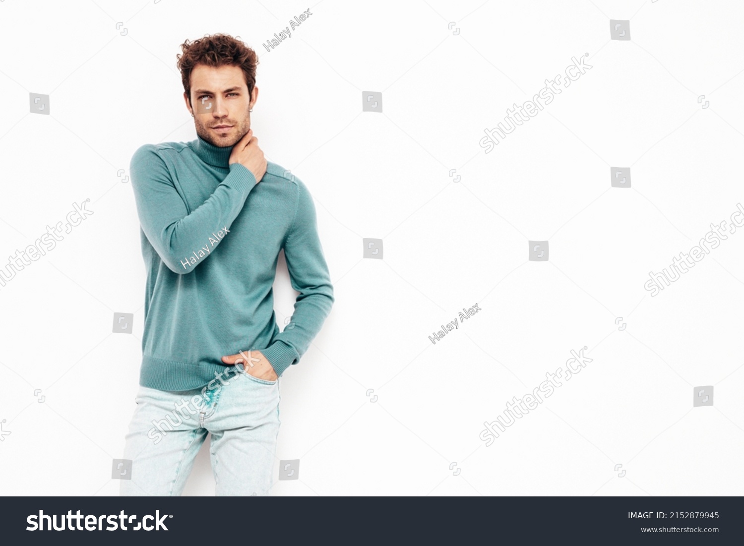 Handsome confident hipster  model.Sexy unshaven man dressed in summer stylish blue sweater and jeans clothes. Fashion male with curly hairstyle posing in studio. Isolated on white #2152879945