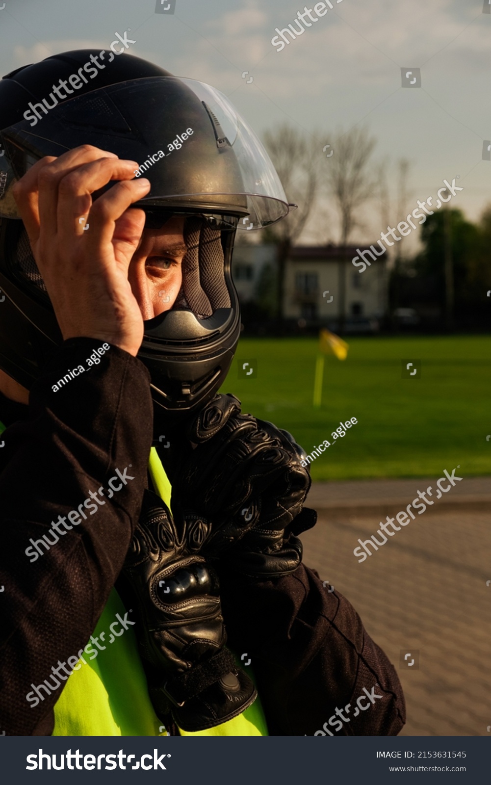 A novice biker is being trained at an atoschool. Close-up of a motorcyclist in a helmet and training vest. Biker emotions. #2153631545