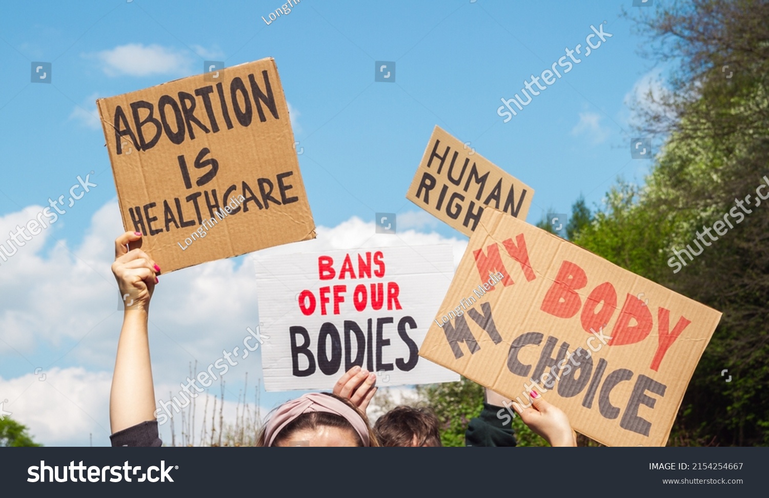 Protesters holding signs Abortion Is Healthcare, My Body My Choice, Bans Off Our Bodies, Human rights. People with placards supporting abortion rights at protest rally demonstration. #2154254667