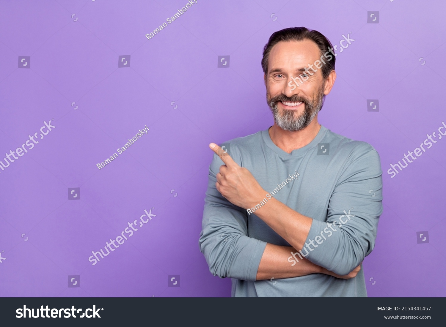 Photo of handsome guy pointing finger empty space promote cool product isolated on violet color background #2154341457