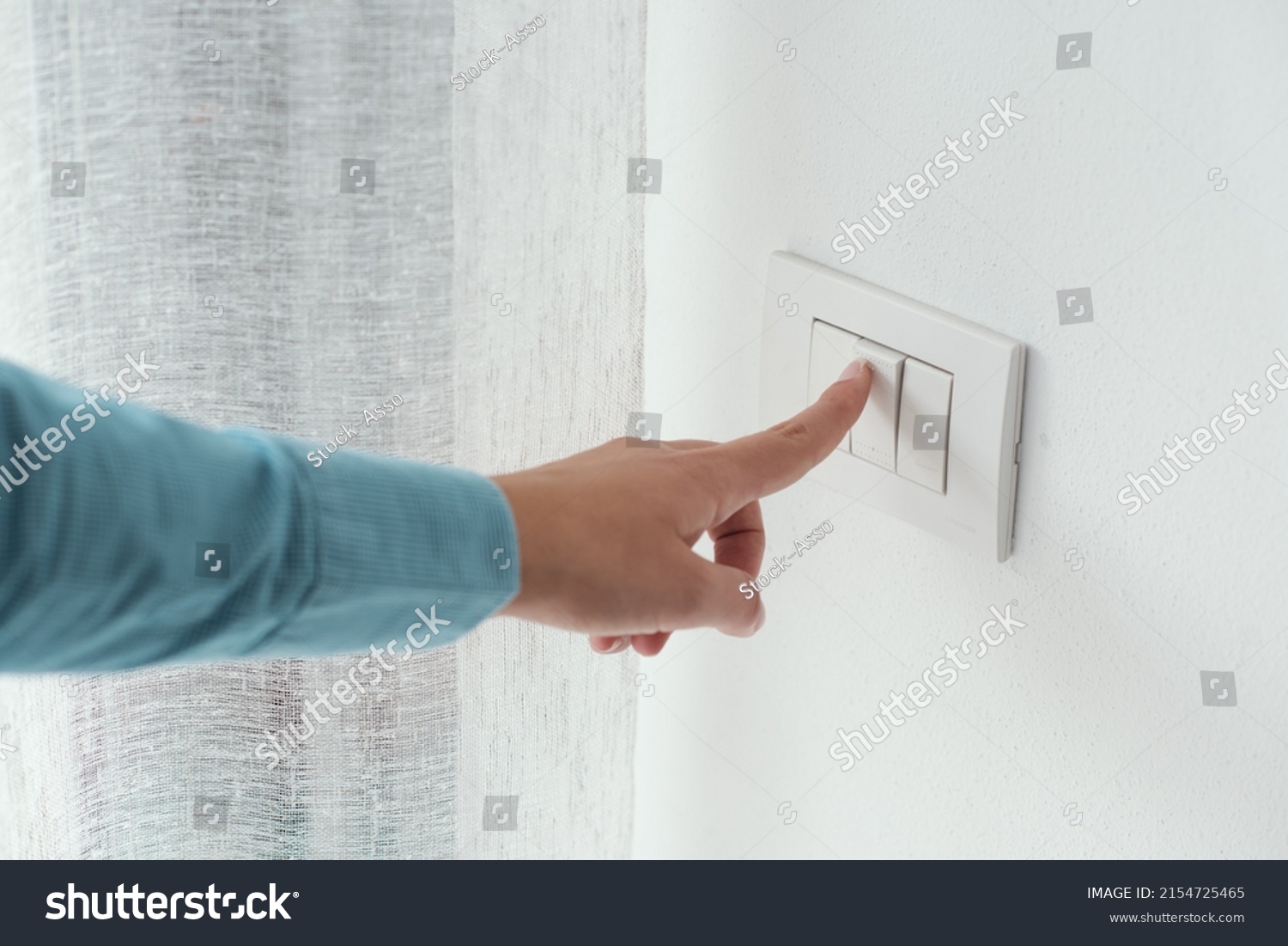 Woman pressing a light switch, energy saving concept #2154725465