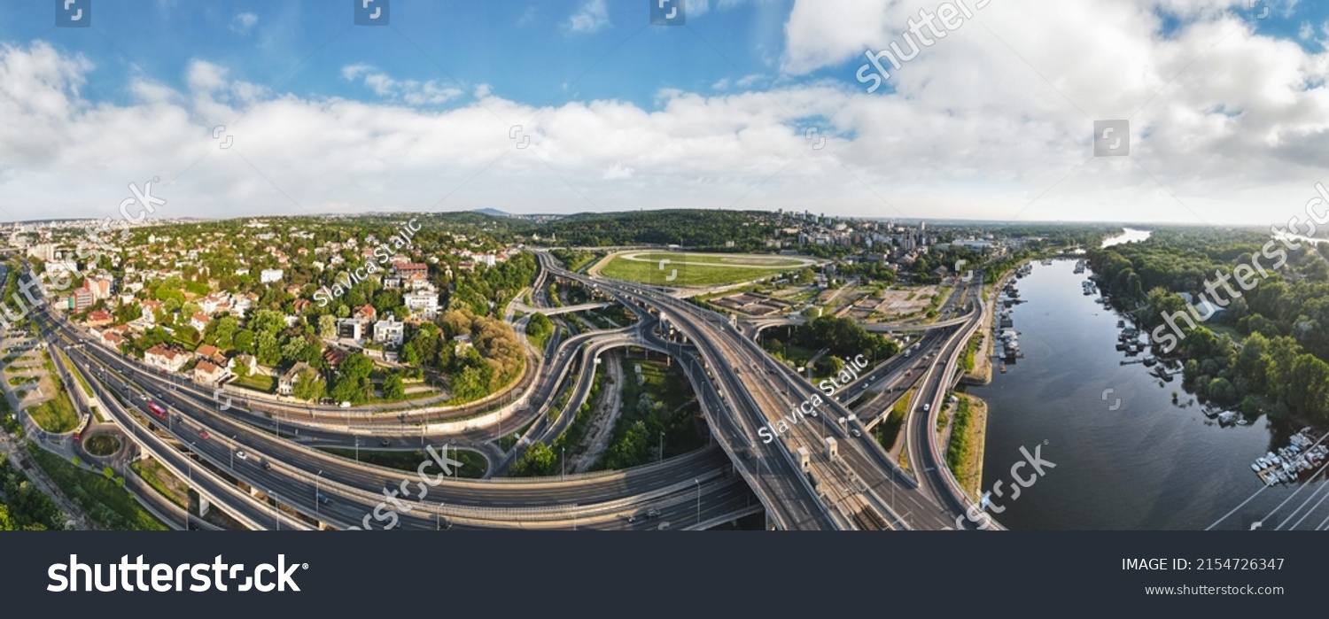 Aerial skyline cityscape view of Belgrade, Serbia, in the morning. Aerial  drone view of   Ada Ciganlija lake, hippodrome and traffic driving over intersection in Belgrade. Urban scene #2154726347
