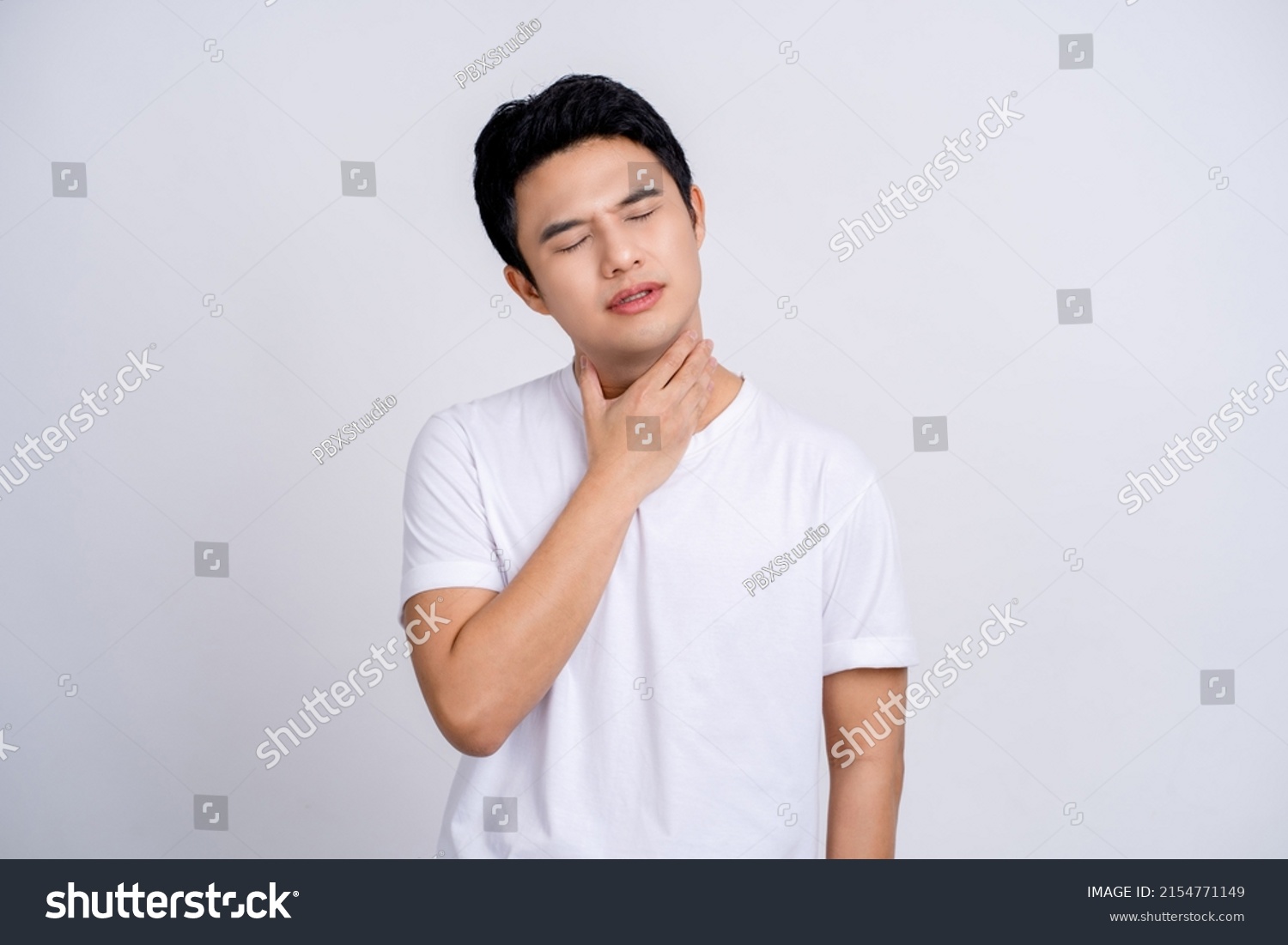 Portrait of young asian man in casual white t-shirt isolated on white background. He had a sore throat and touched his throat. Difficult to swallow. #2154771149