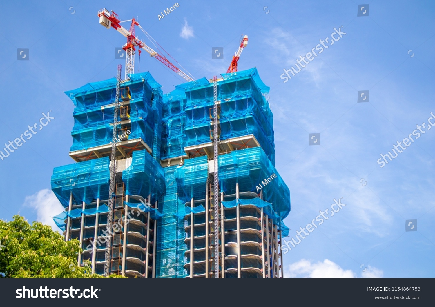 Two multistory buildings, the facade is covered with protective construction mesh on a background of a blue sky. Construction of residential buildings, skyscrapers in big city. Construction cranes. #2154864753