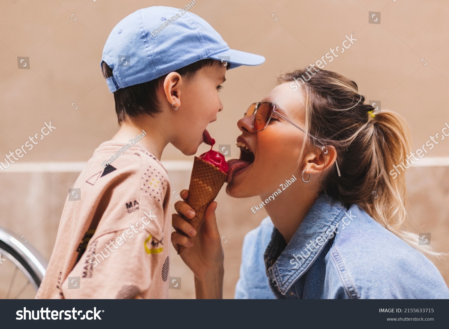 Woman with her son enjoying family time walking in the city together on a sunny day, eating ice cream. Happy family parent with little child boy kid enjoy outdoor lifestyle. Mum and sun lick gelato. #2155633715