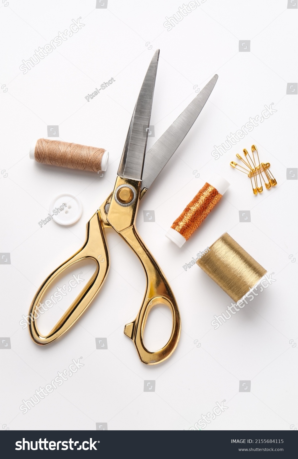 Thread spools with scissors, button and pins on white background #2155684115