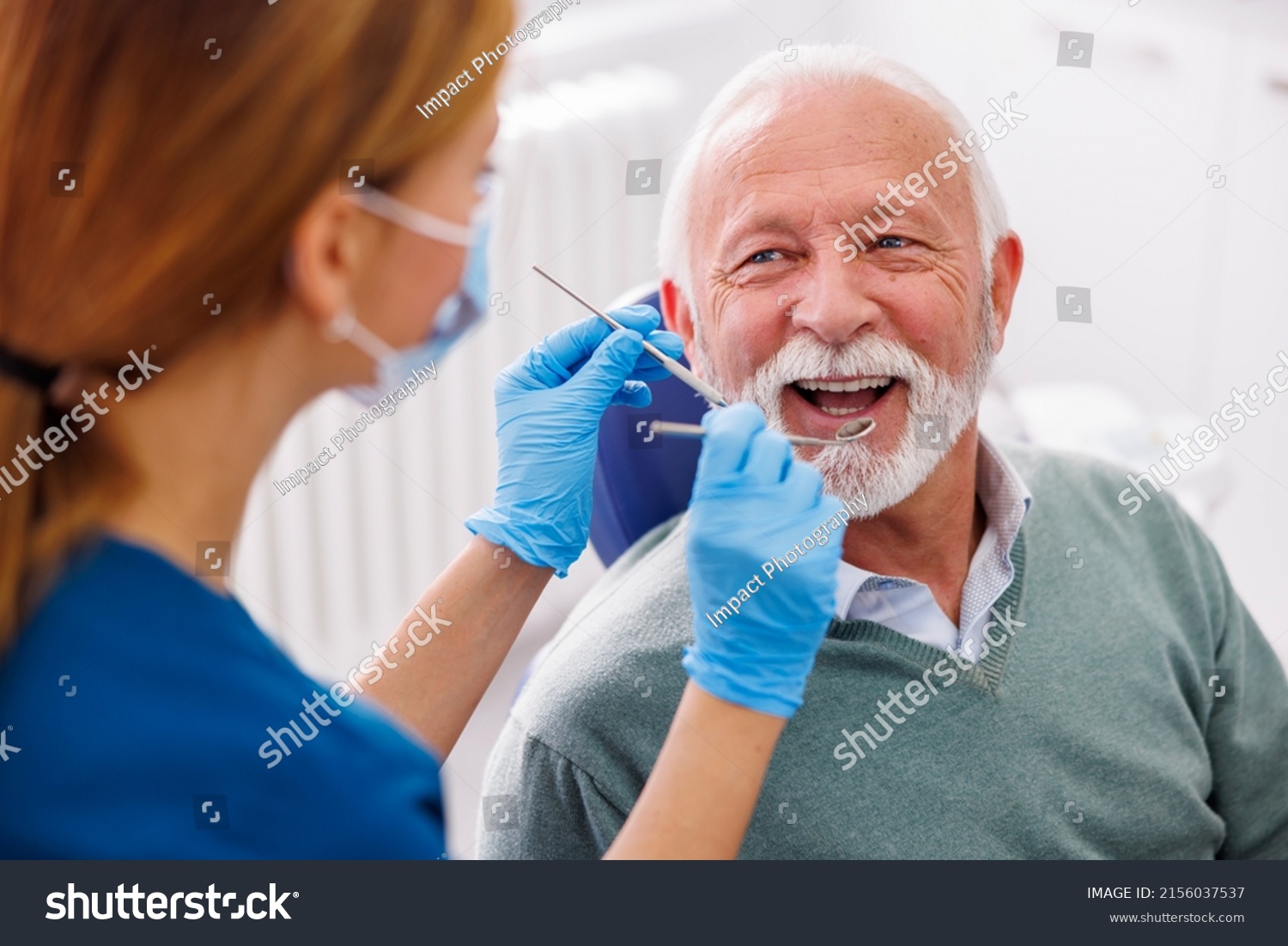 Doctor checking up patient's teeth at dentist office; senior man at dental checkup #2156037537