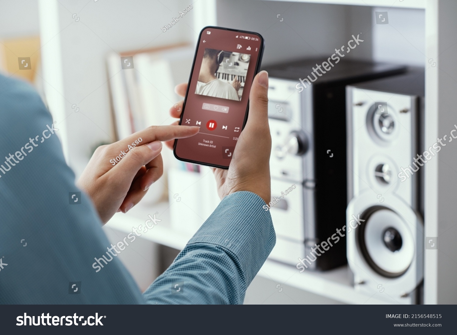 Woman playing music online on her stereo using her phone #2156548515