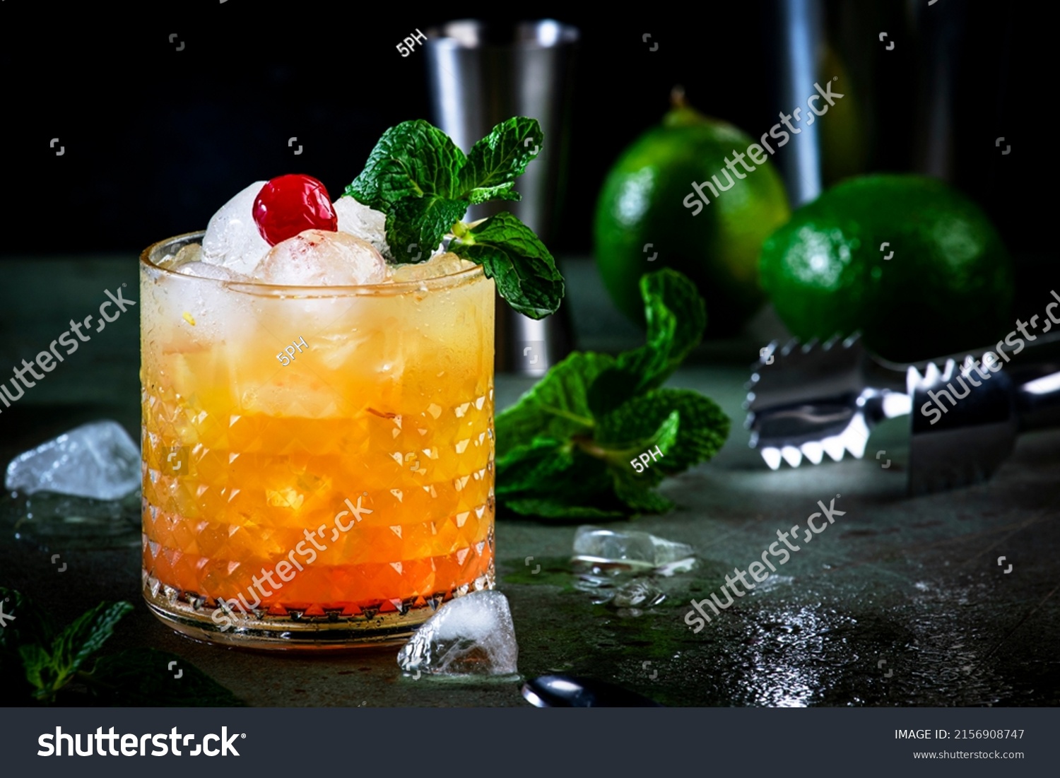 Mai Tai popular alcoholic cocktail with rum, liqueur, syrup, lime juice, mint and crushed ice. Dark green background, steel bar tools, negative space #2156908747
