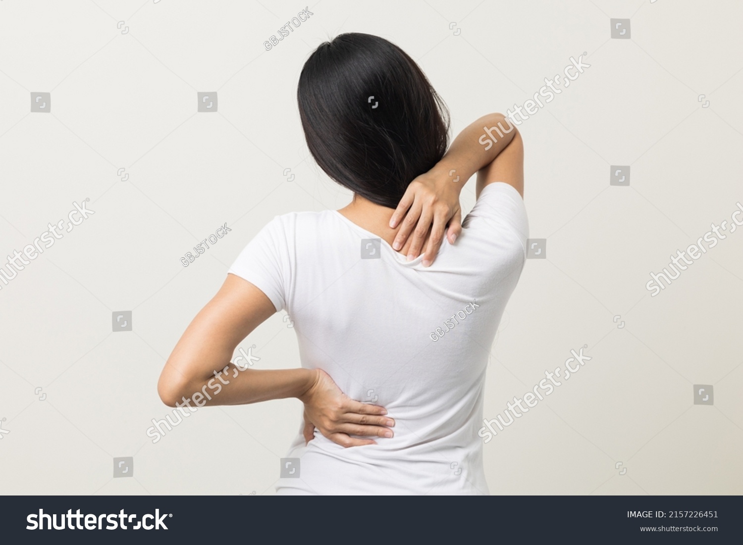 Asian woman has problem with structural posture She had neck and back pain. She massaged her neck and shoulders for relief. reduce muscle tension. Standing on isolated white background #2157226451