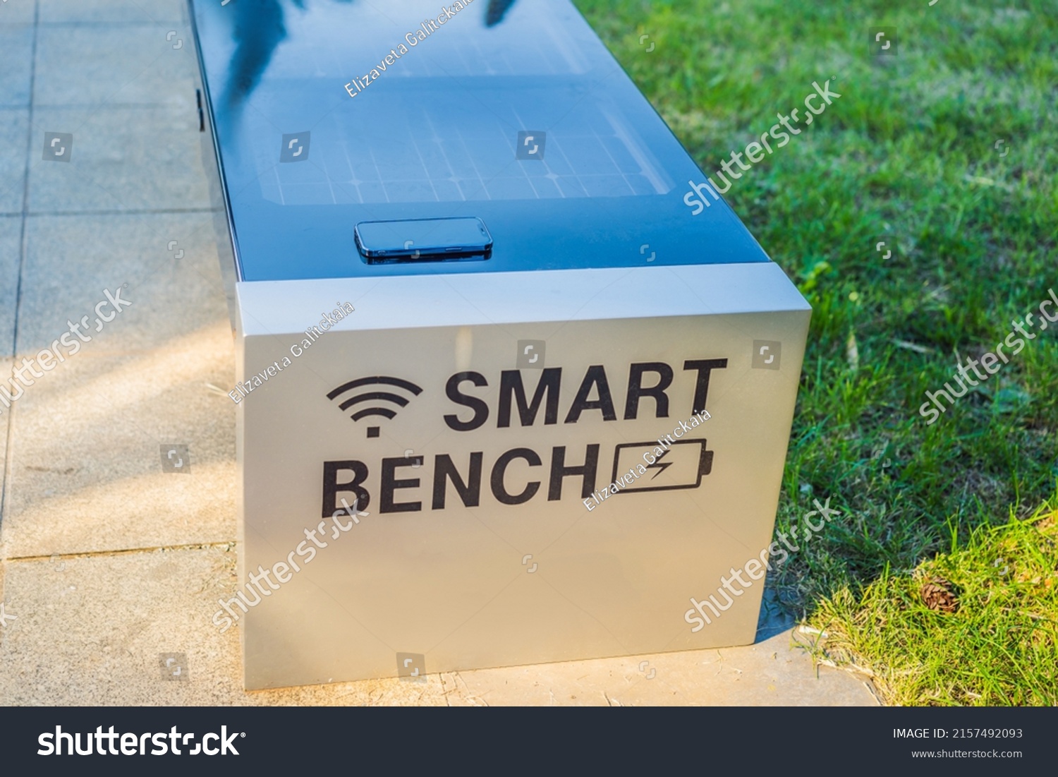 New smart bench in local public park used for charging mobile phones while providing wireless network #2157492093