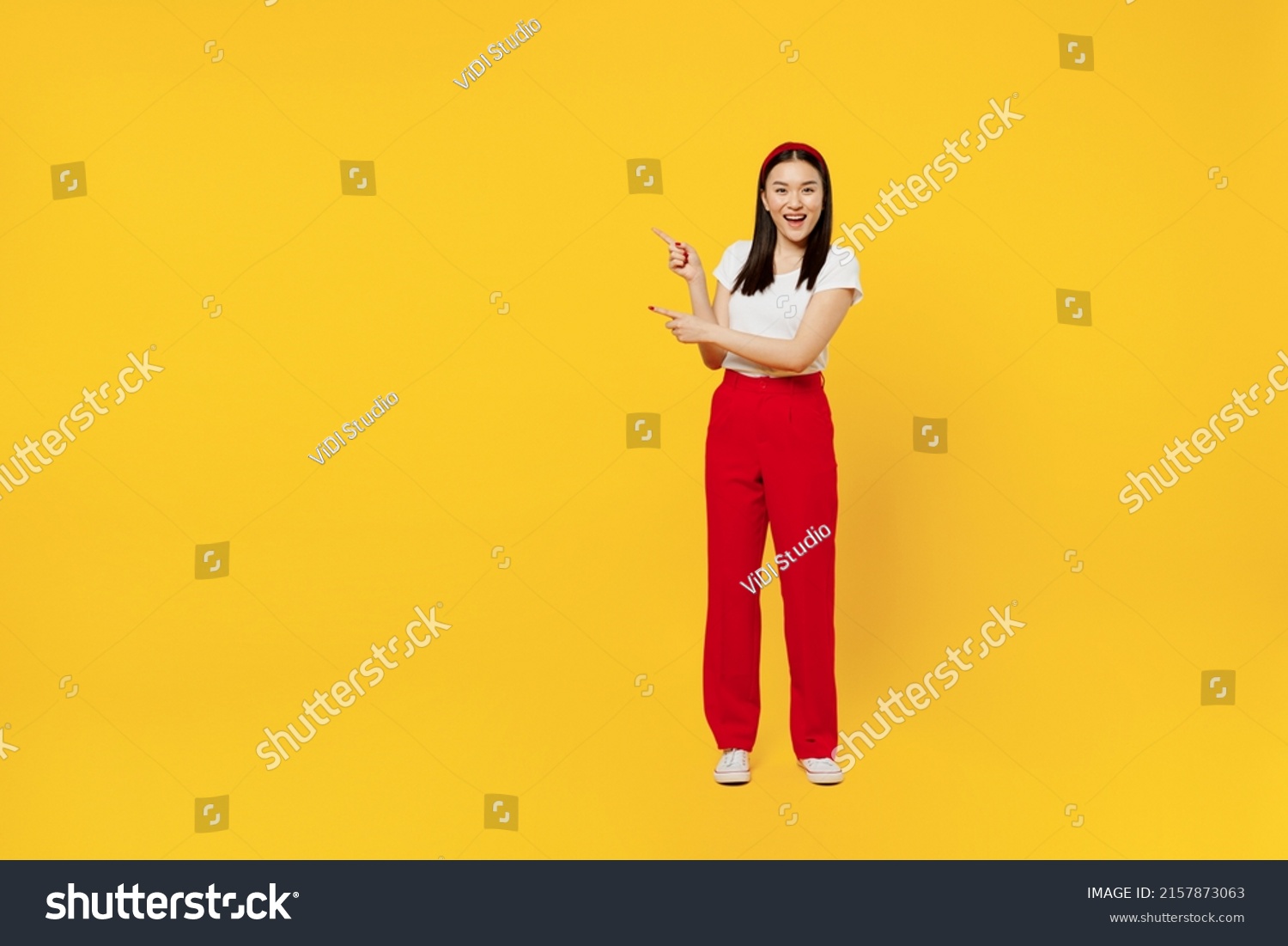 Full size body length promoter young woman of Asian ethnicity 20s years old in casual clothes point aside on workspace area copy space mock up isolated on plain yellow background studio portrait #2157873063