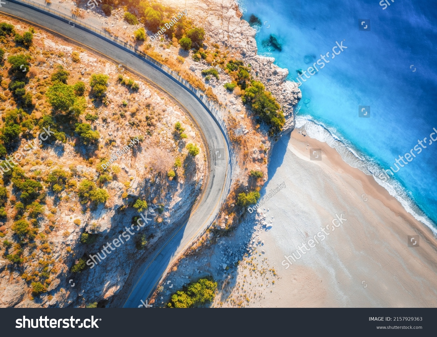 Aerial view of mountain road near blue sea with sandy beach at sunset in summer. Oludeniz, Turkey. Top view of road, trees, azure water, mountain. Beautiful landscape with highway, rocks, sea coast	 #2157929363